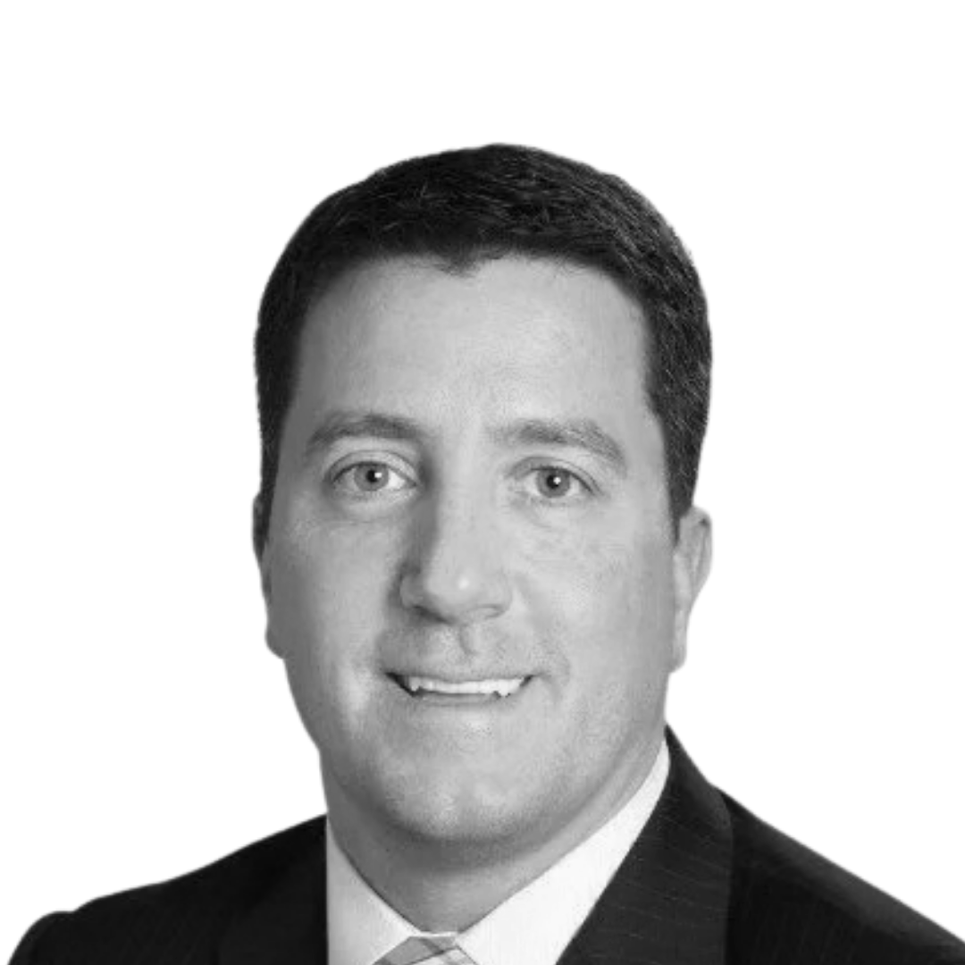Black and white professional portrait of a man in a suit and tie, smiling at the camera.