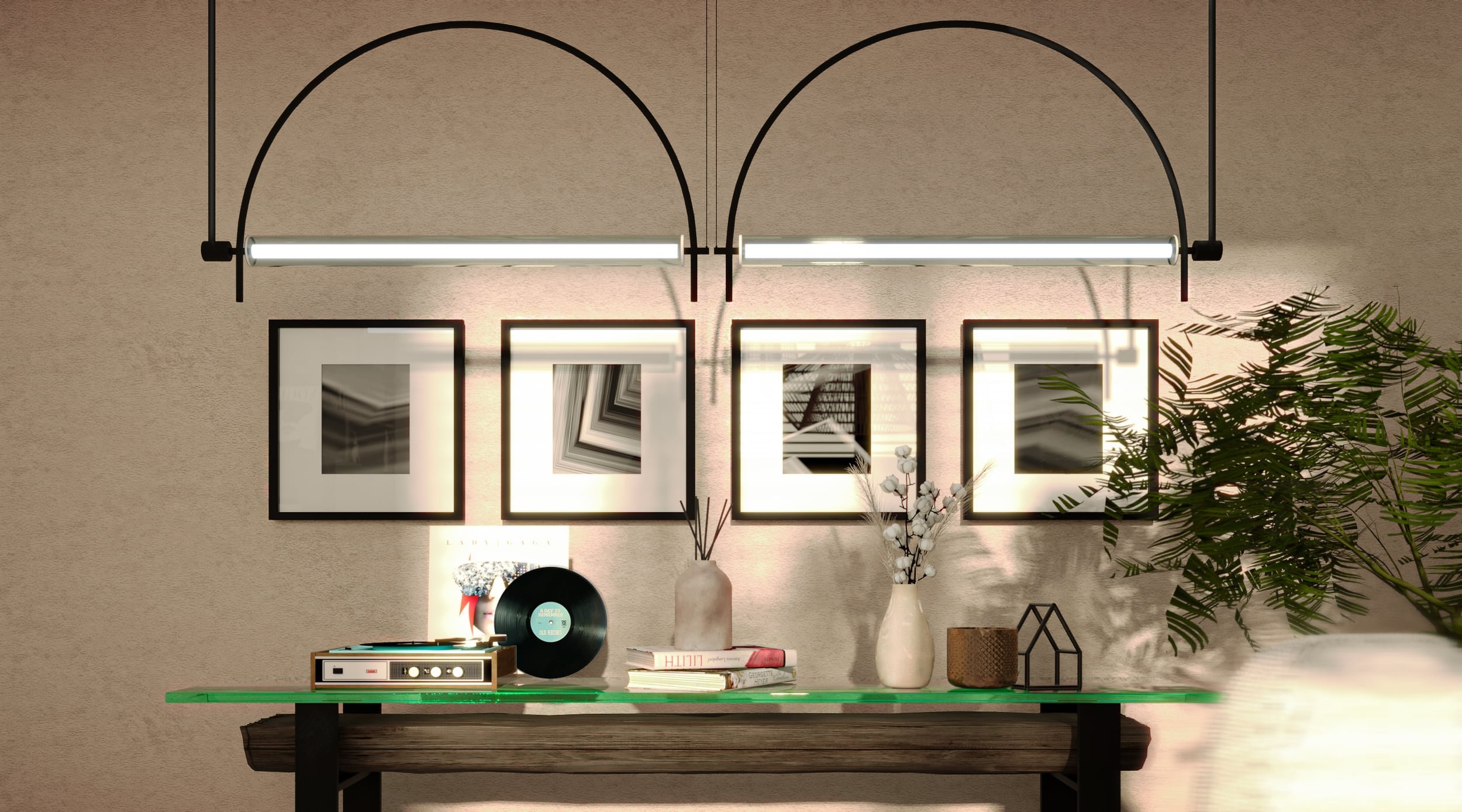 Interior decor scene with four framed abstract art pieces on a beige wall, a green glass table with decorative items including a vinyl record player, a vinyl record, books, vases, and plants, accented with black lighting fixtures and modern art.