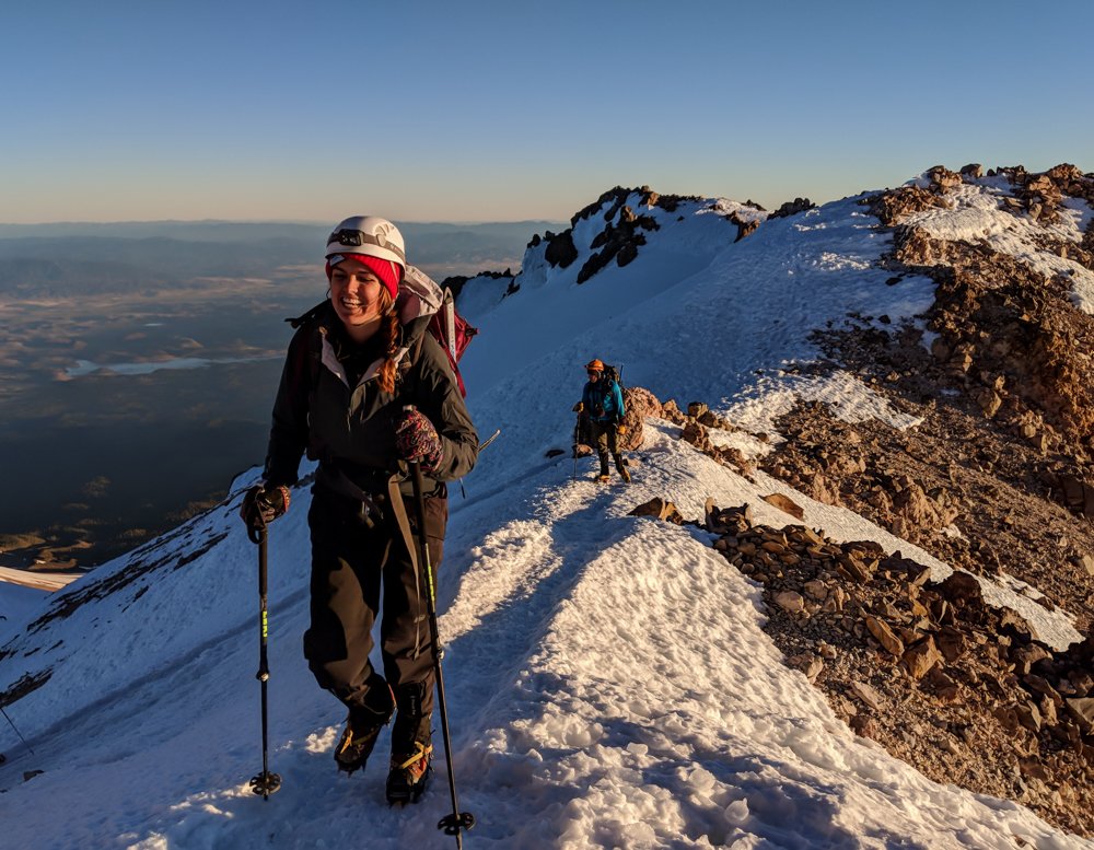 Female climber walks ridge on mt shasta