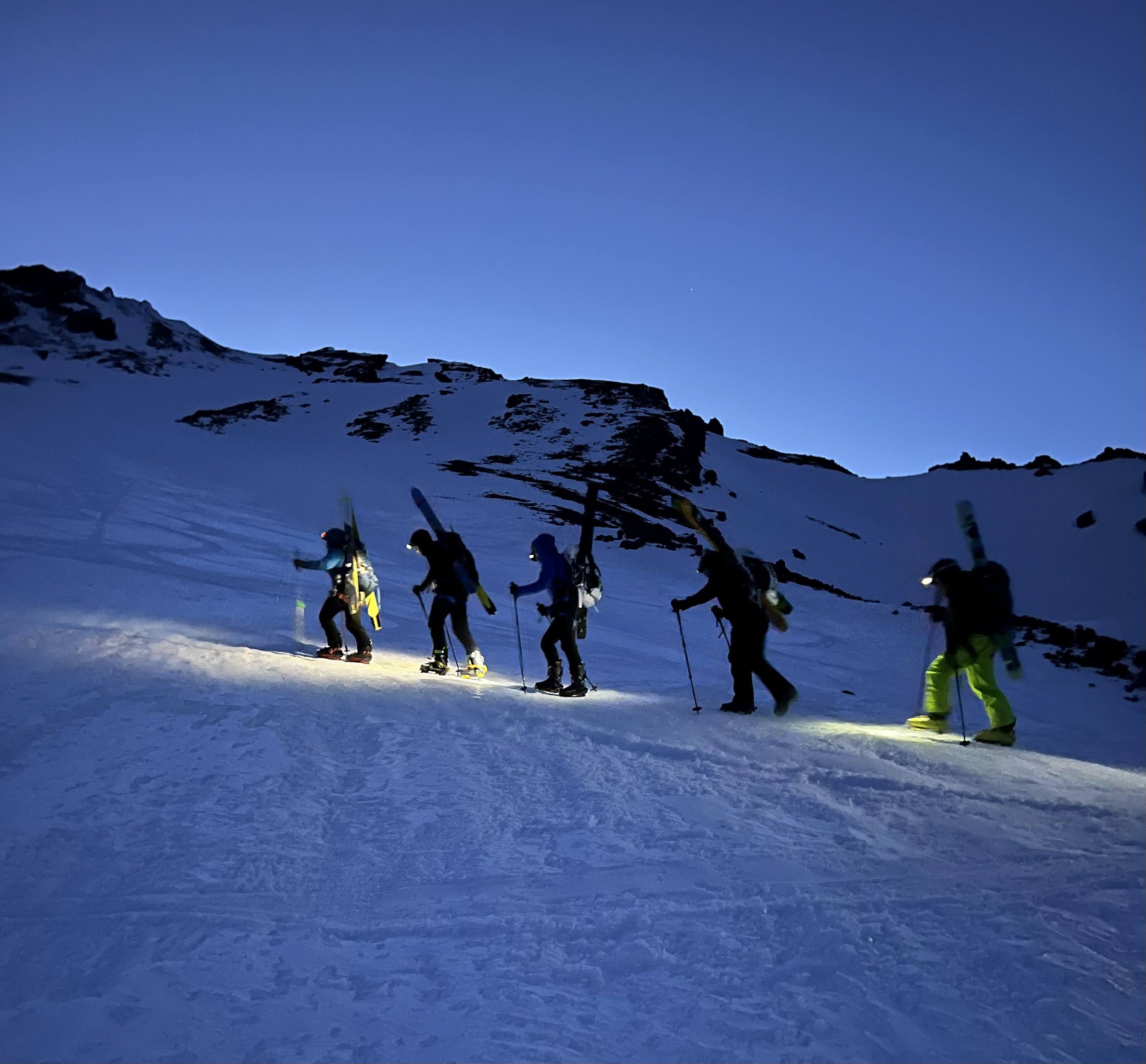Backcountry skiers during sunset of an alpine start