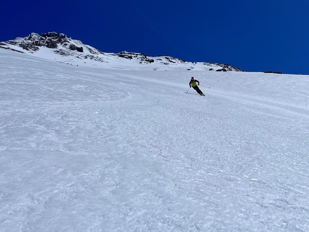 Skiing down mt shasta with the peak of mt shasta in the background