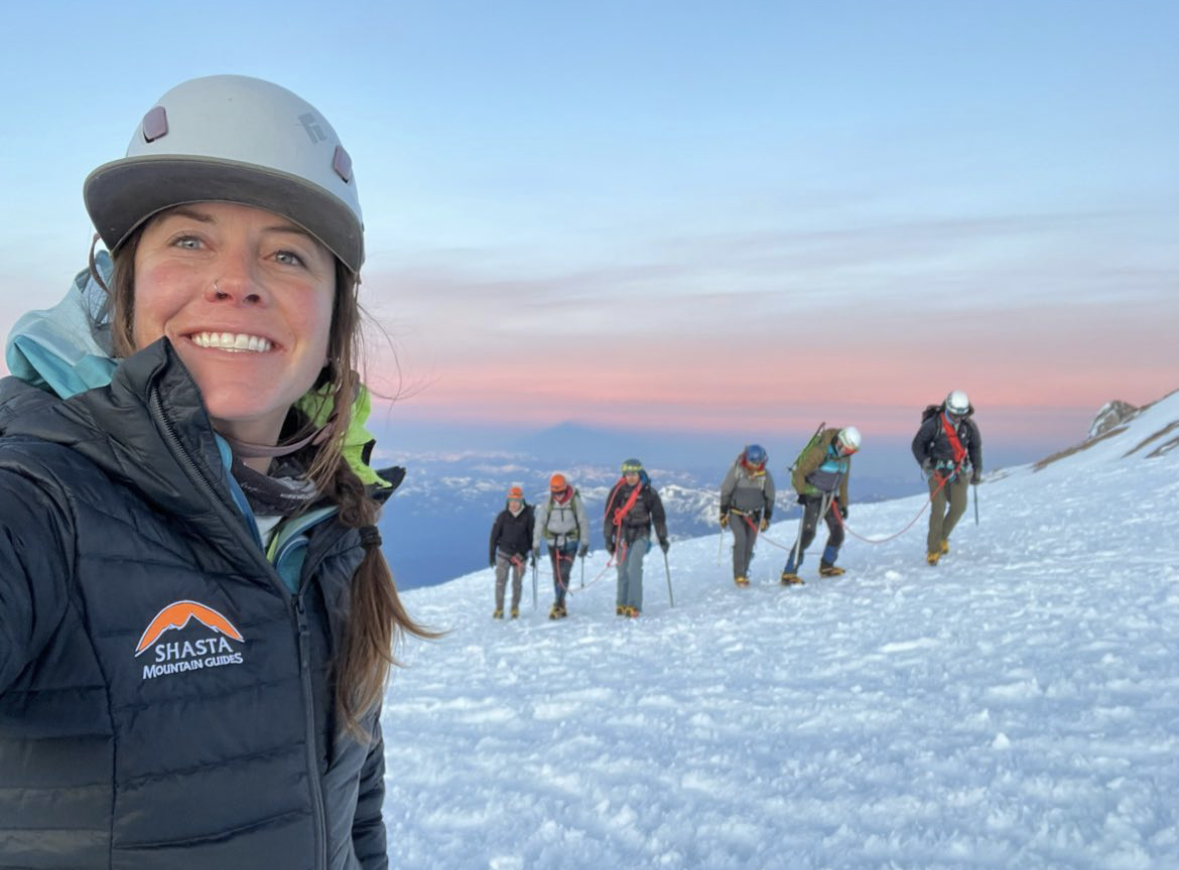 Female Shasta guide poses with Womens mountaineering course on Mt Shasta