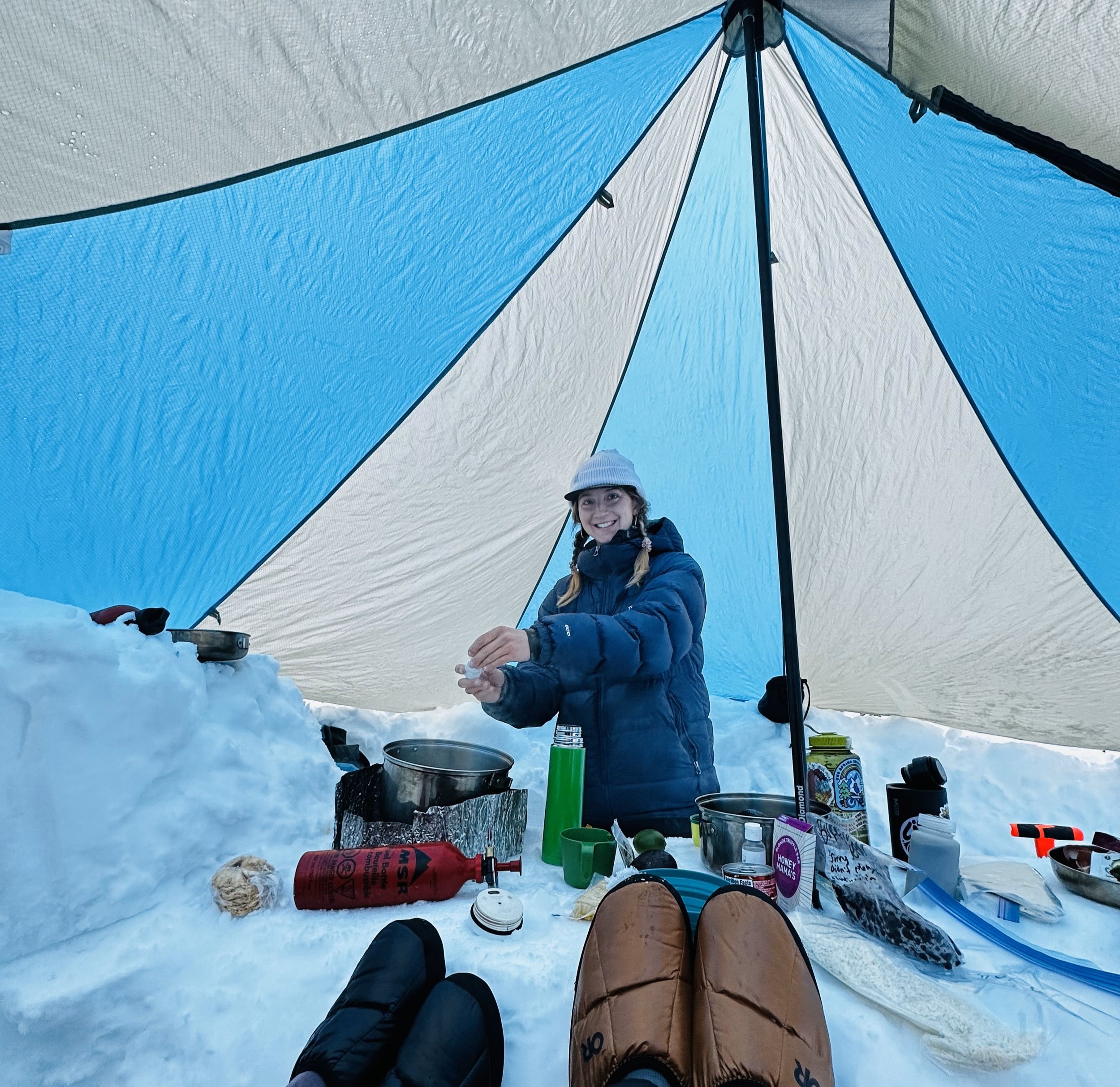 Shasta mountains guide- Tailor prepares a meal in the tent at base camp