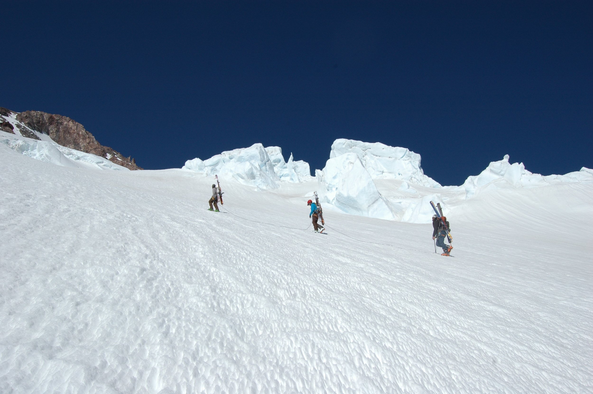 Group of ski mountaineers climb toward the summit.