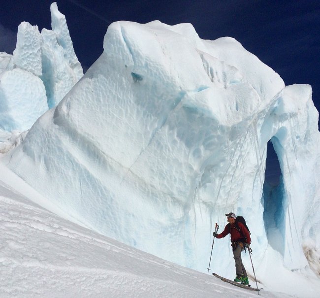 Skier tours up mt shasta next to a glacier
