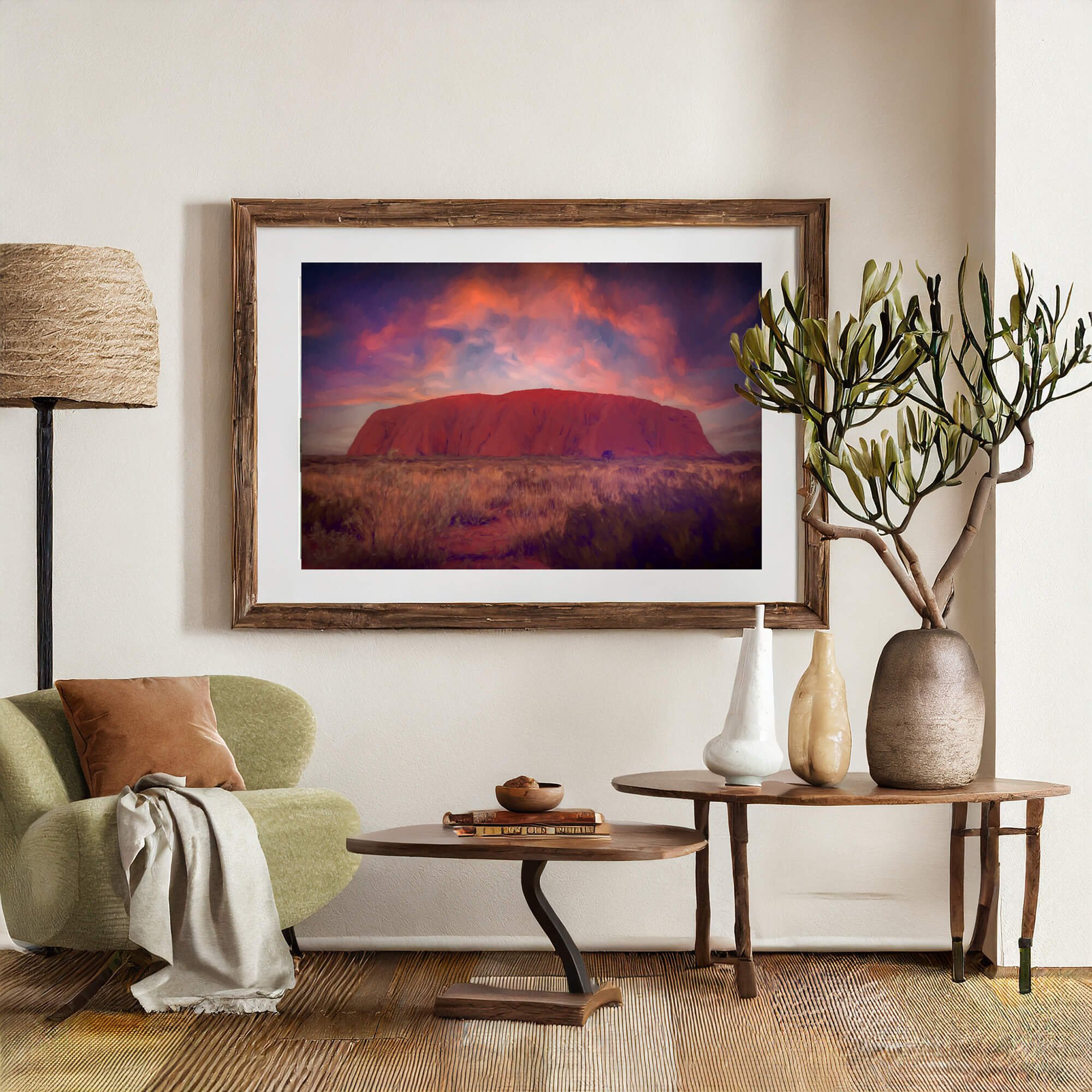 Framed photo of Uluru at sunset in a cozy room with plants and a lamp.