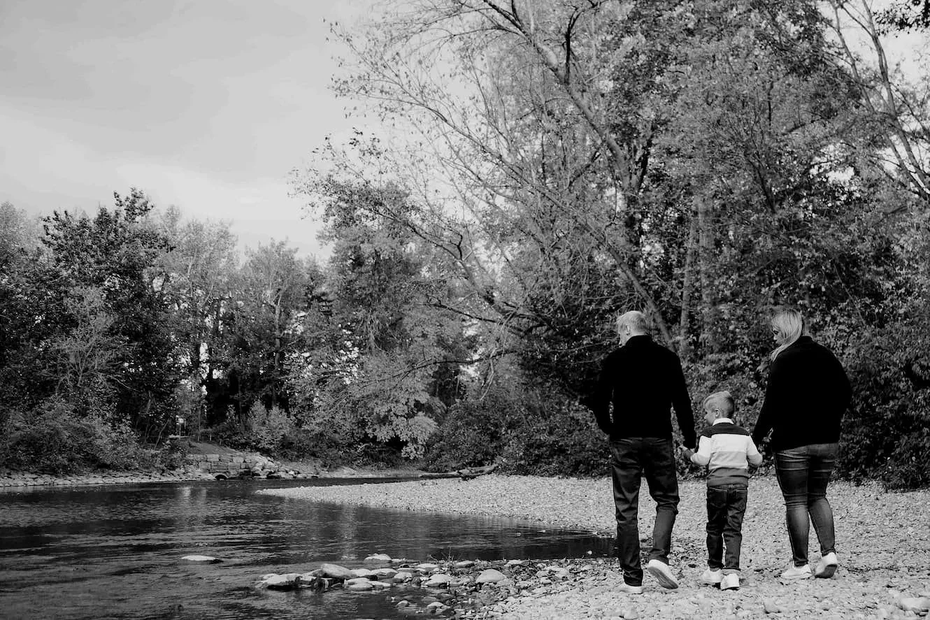 Family portrait photo of a family walking along the Elbow River in Calgary during the fall time