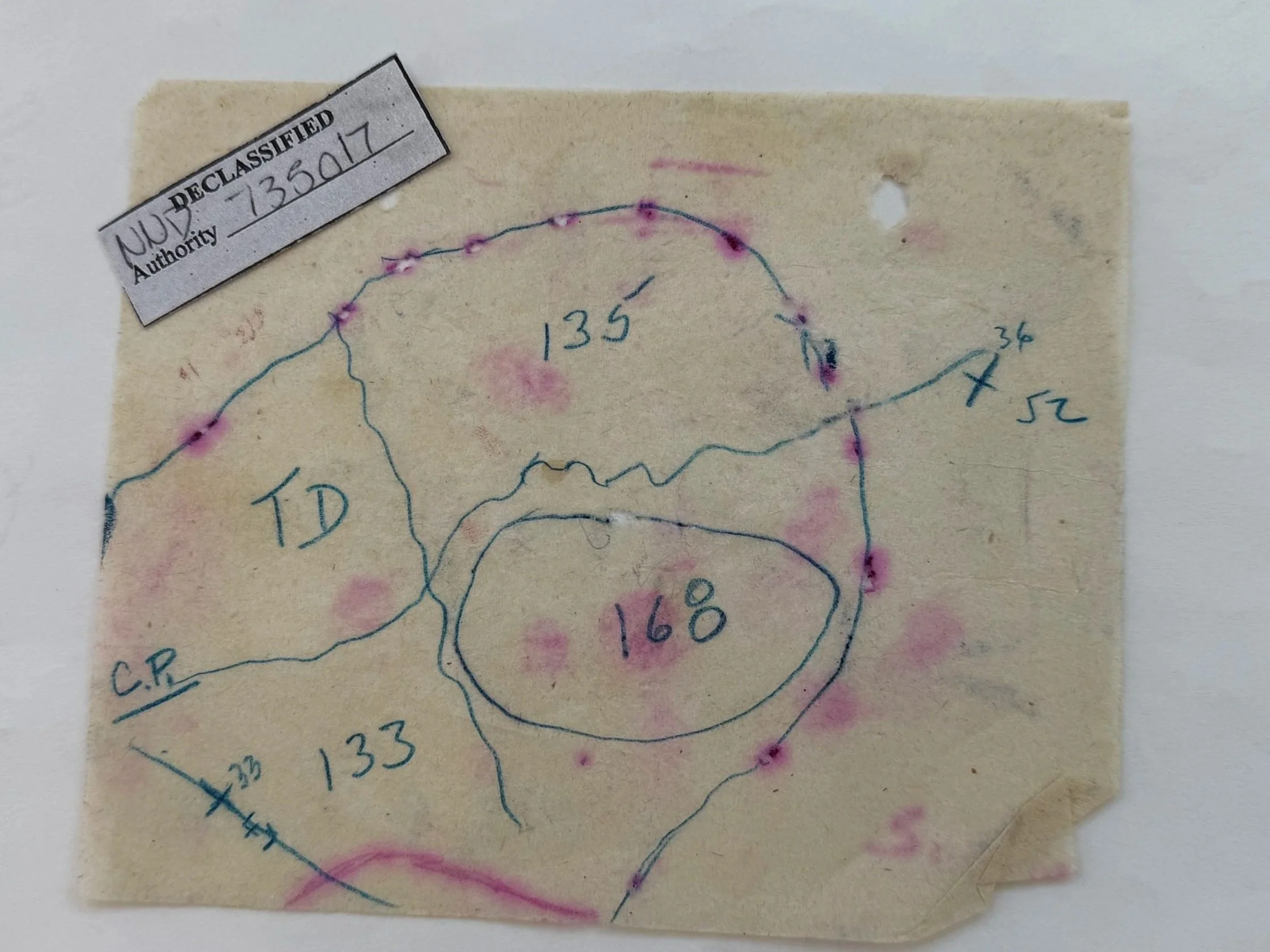 Photo of a small slip of paper showing a declassification tag and a hand drawn map