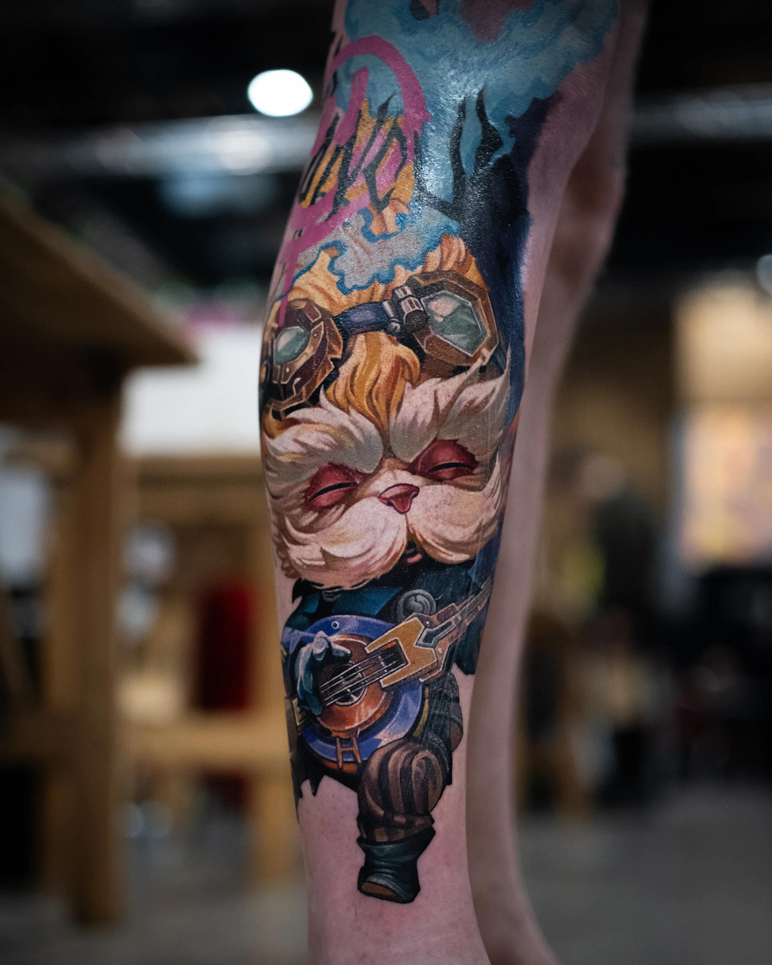 Tattoo of a cat playing a guitar on a person's arm.