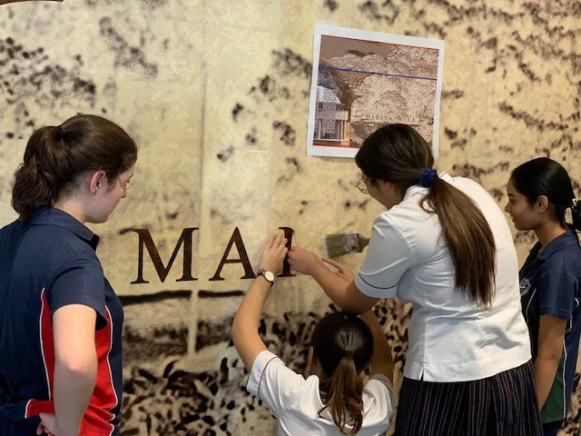 Year 12 HSC Art Students St. Clare’s College Waverley installing the individual letter R from the word MARNA (First) which they had previously cut out.  Printed from the same digital file as the underlying image substrate these overlays are aligned w