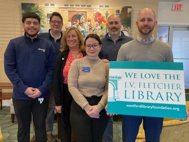 Westford branch team members stand in front of a painting in the lobby.
