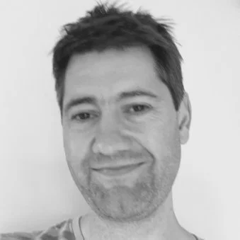 Black and white close-up photo of a man smiling.