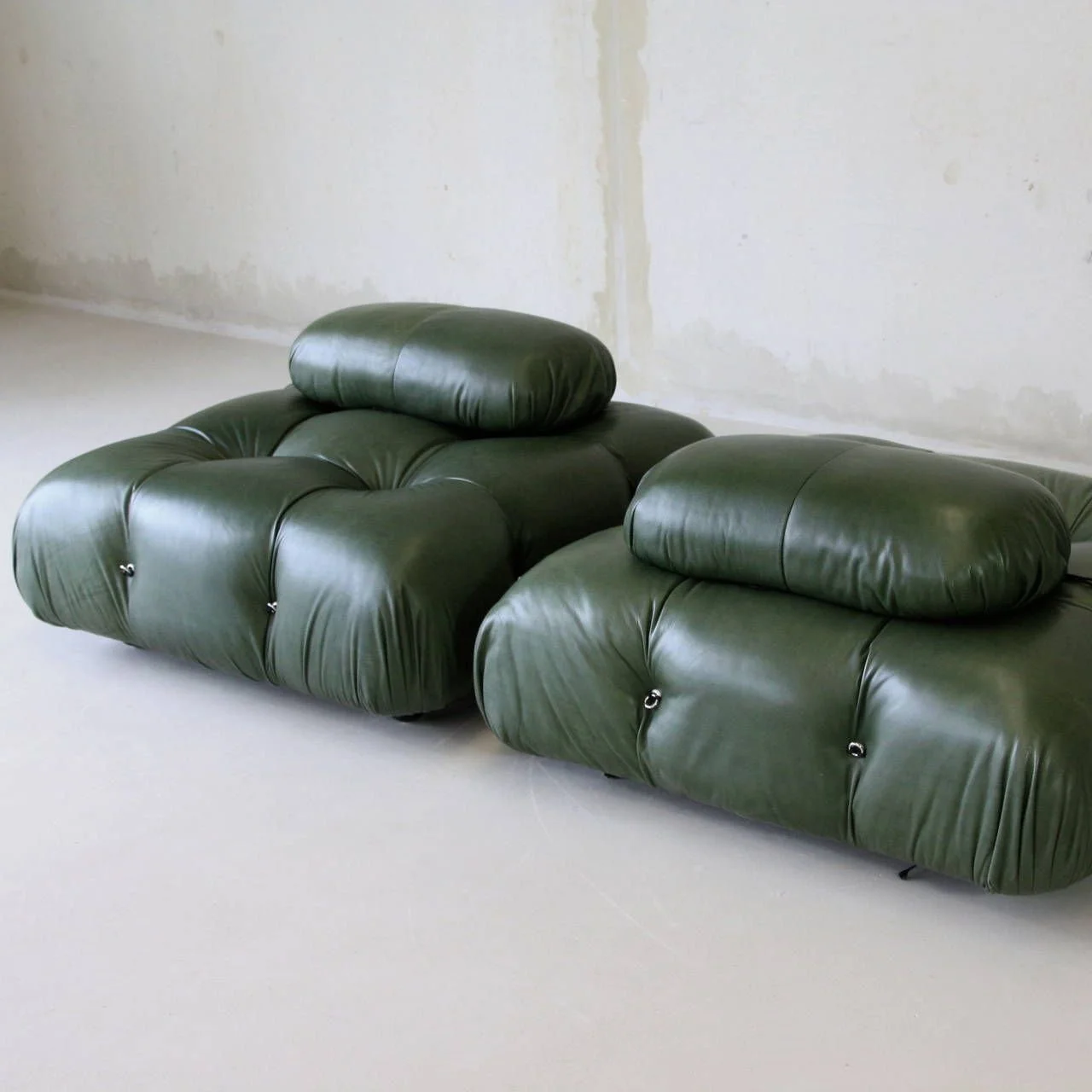 picture of a green couch in an empty white room