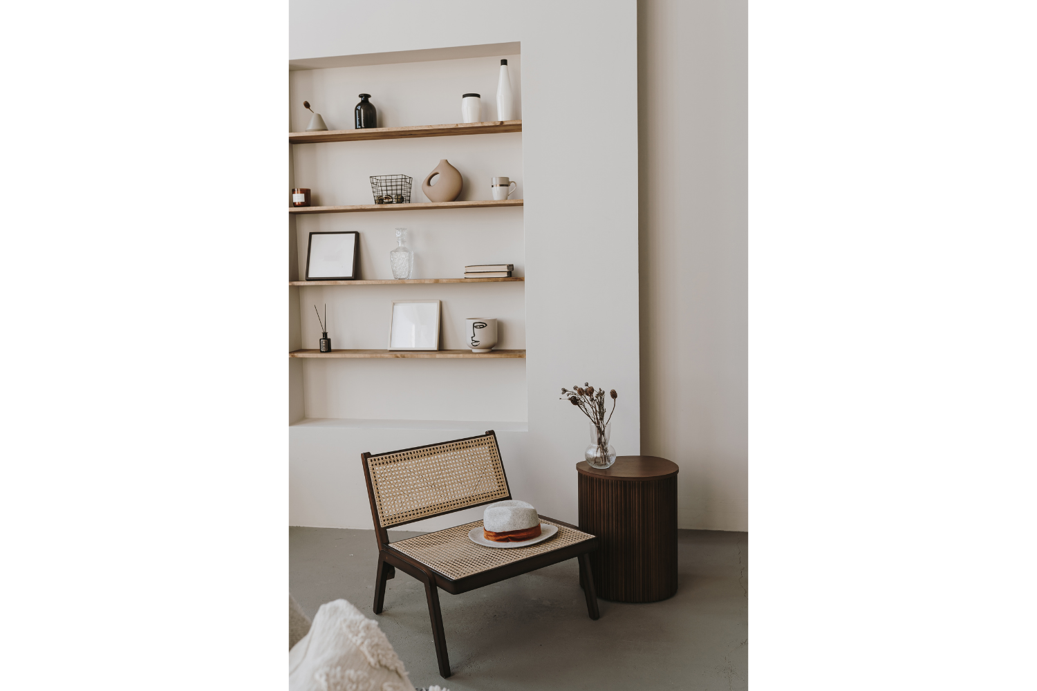 Minimal custom built-in shelving with natural wood shelves and curated décor, illustrating how thoughtful design and restraint create a refined, luxurious interior.