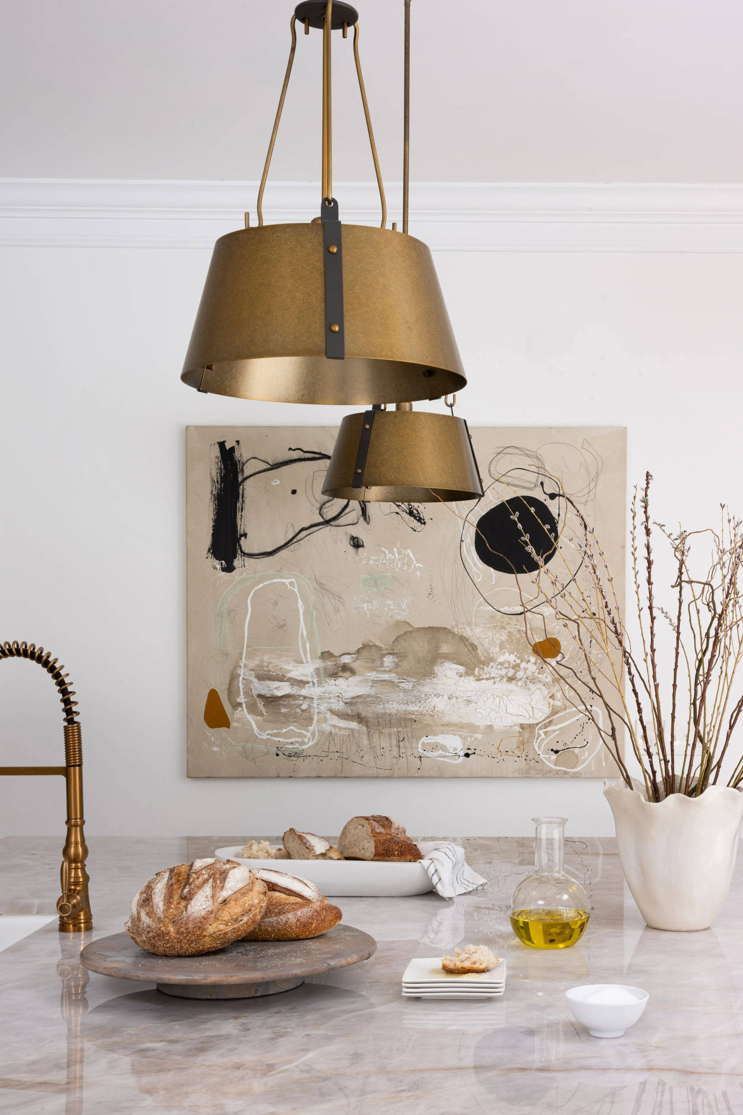 Kitchen styling detail with quartzite countertop, pendant lighting, statement artwork and warm natural accents by House of Shima