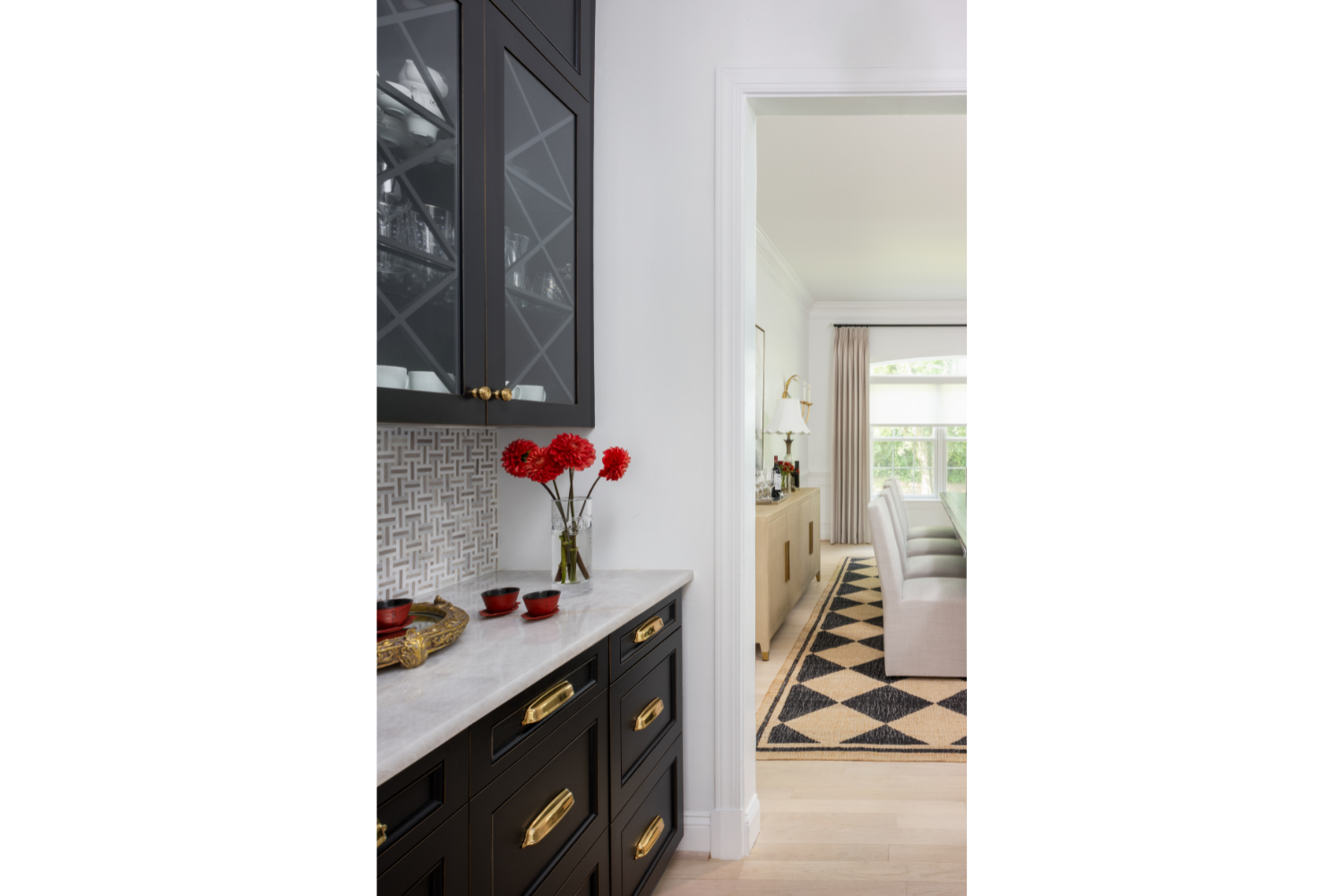 Custom black cabinetry with glass-front upper cabinets and brass hardware, showcasing timeless millwork that adds beauty, functionality, and lasting value to the home.