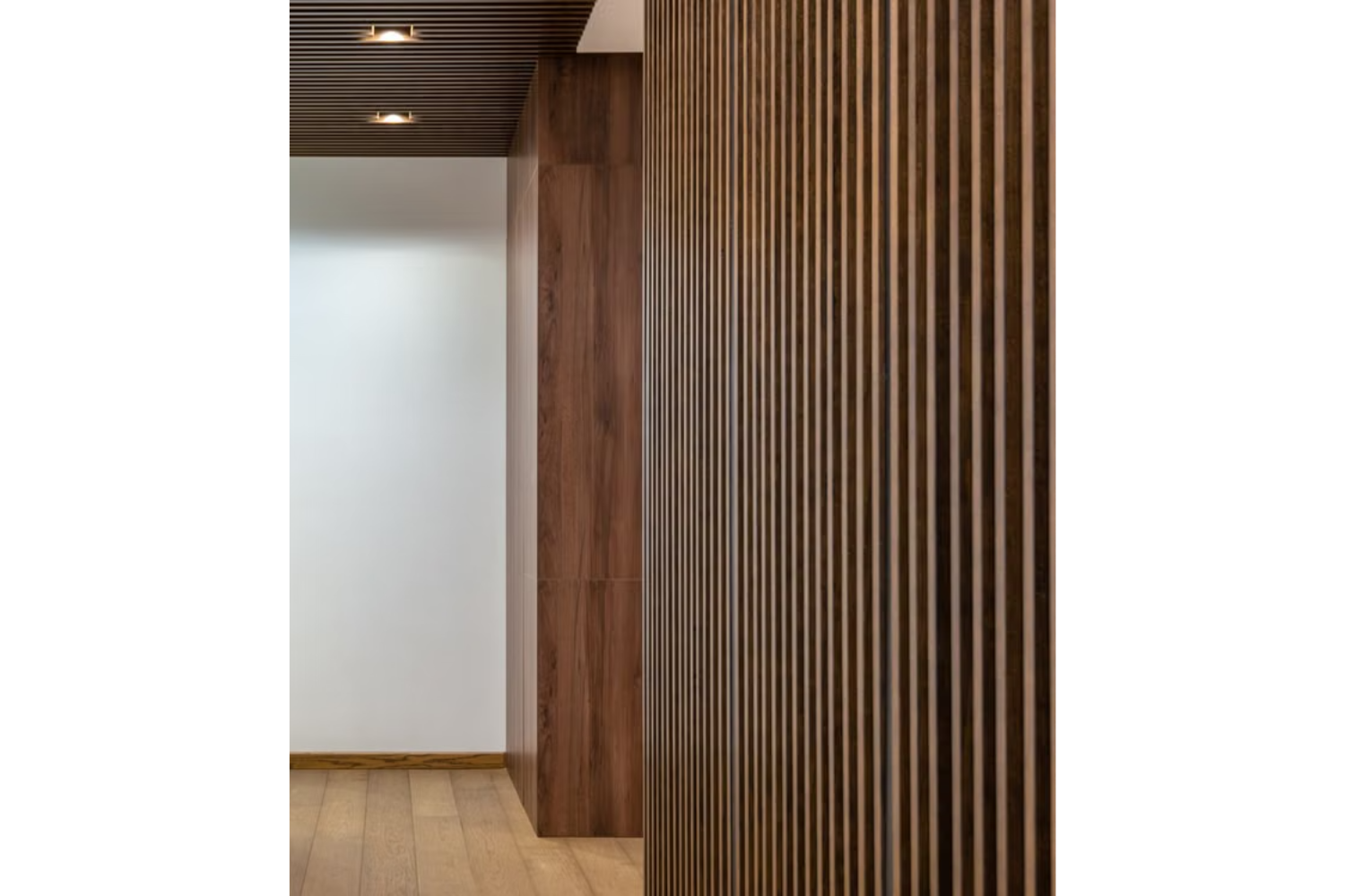 Contemporary interior with warm wood slat wall paneling and coordinating wood ceiling detail.