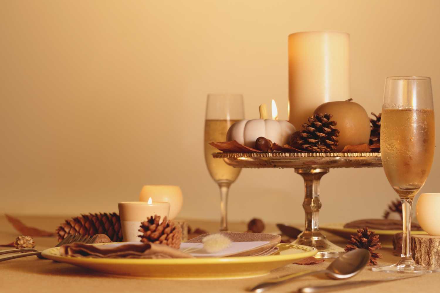 Warm holiday table setting featuring layered textures and seasonal décor