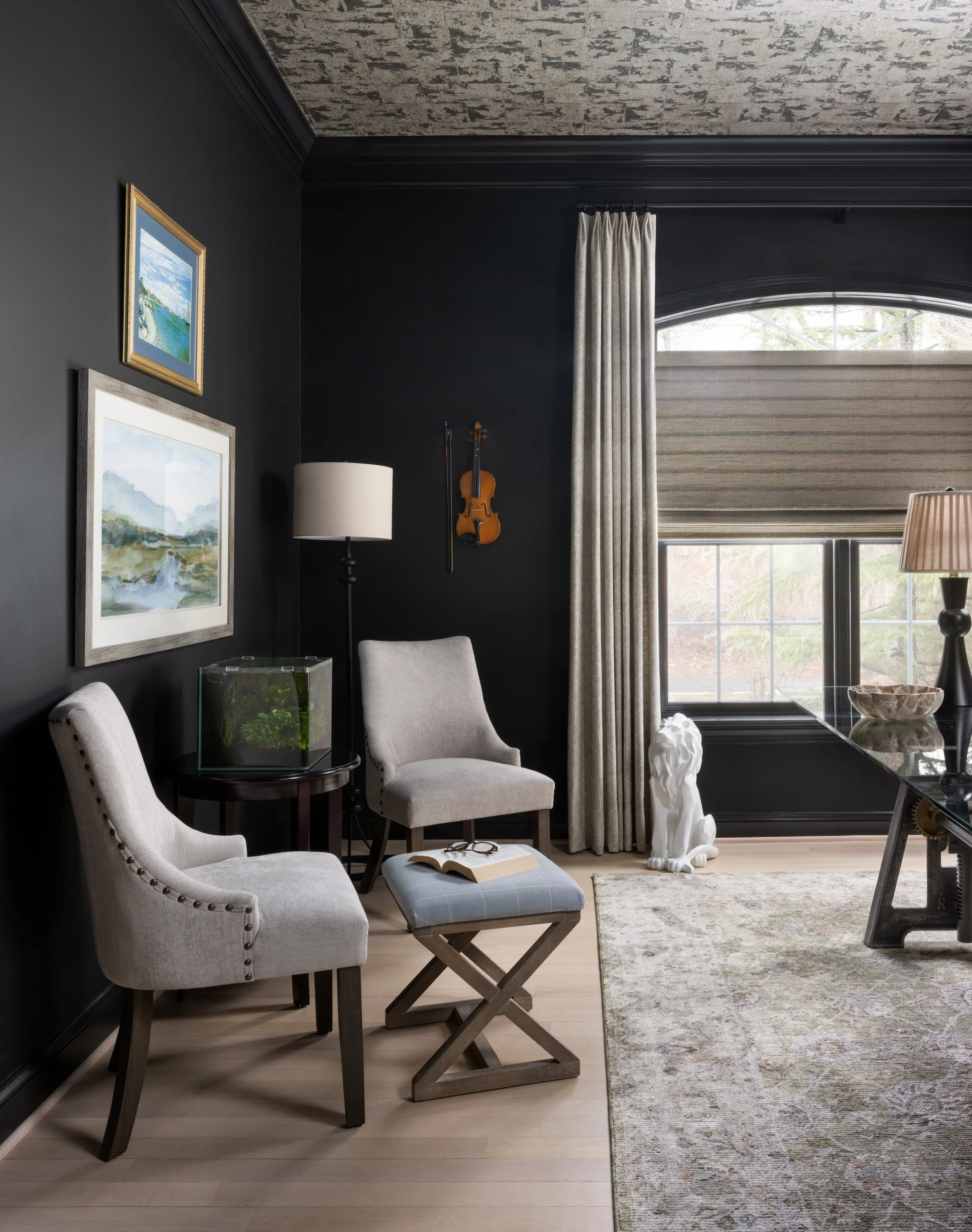 Sophisticated home office seating area designed by House of Shima, featuring Benjamin Moore Onyx walls, custom tailored window treatments, upholstered armchairs, curated artwork, and layered lighting.