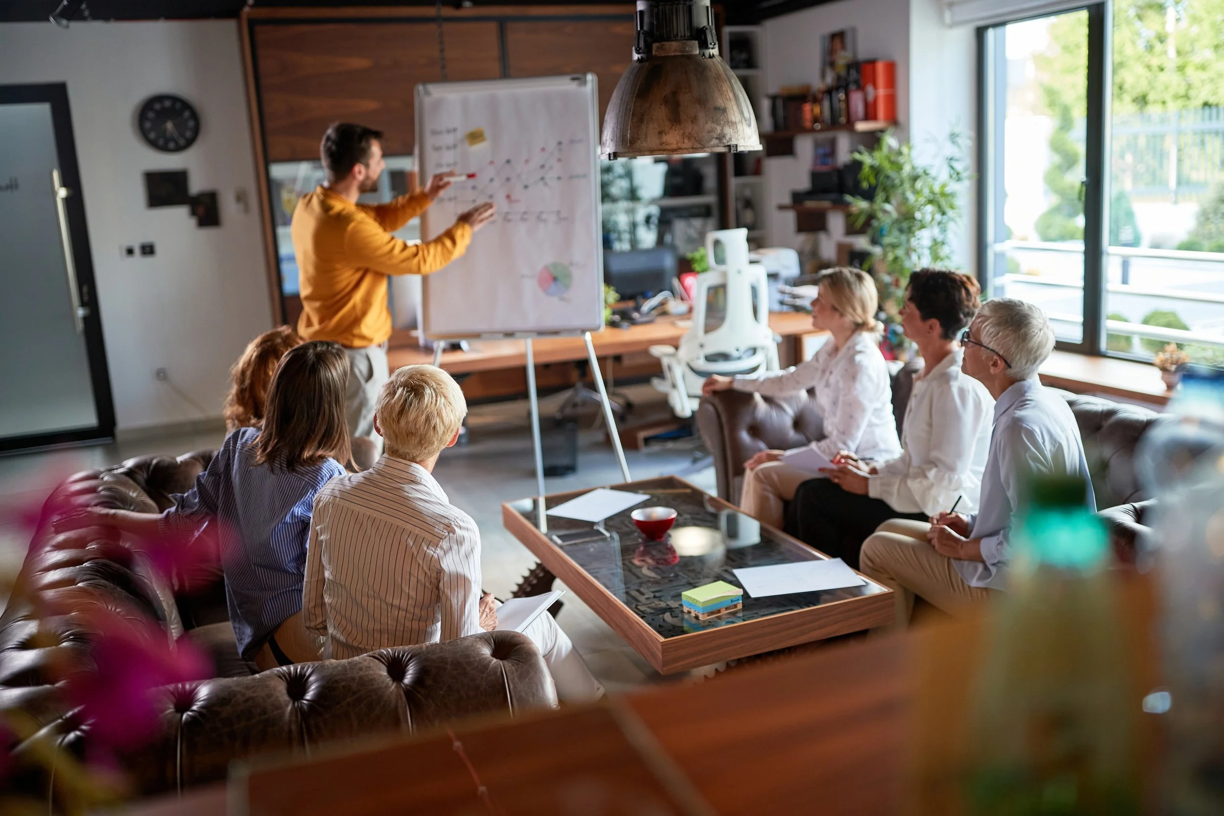 Personne qui présente un tableau devant un groupe de personnes