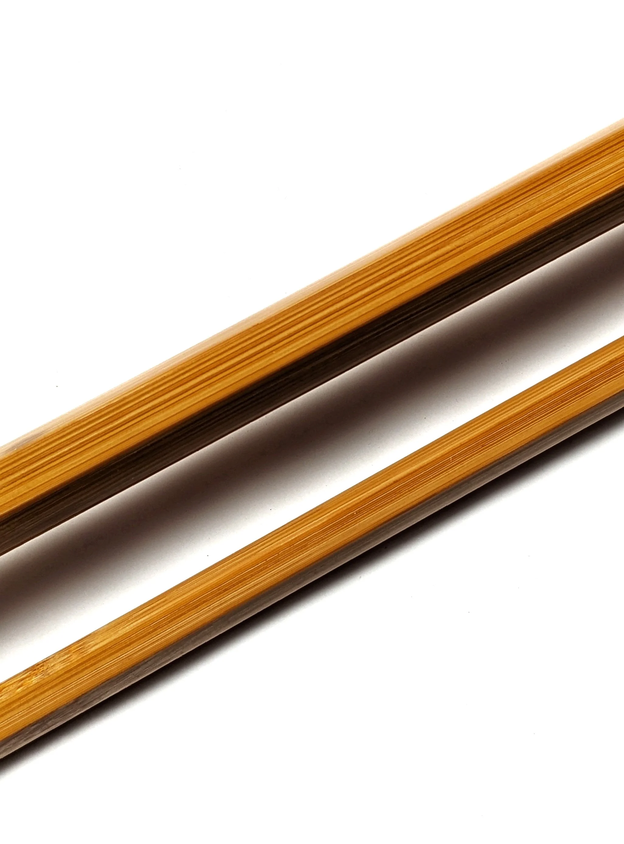 Close-up of several wooden chopsticks arranged diagonally on a white surface.