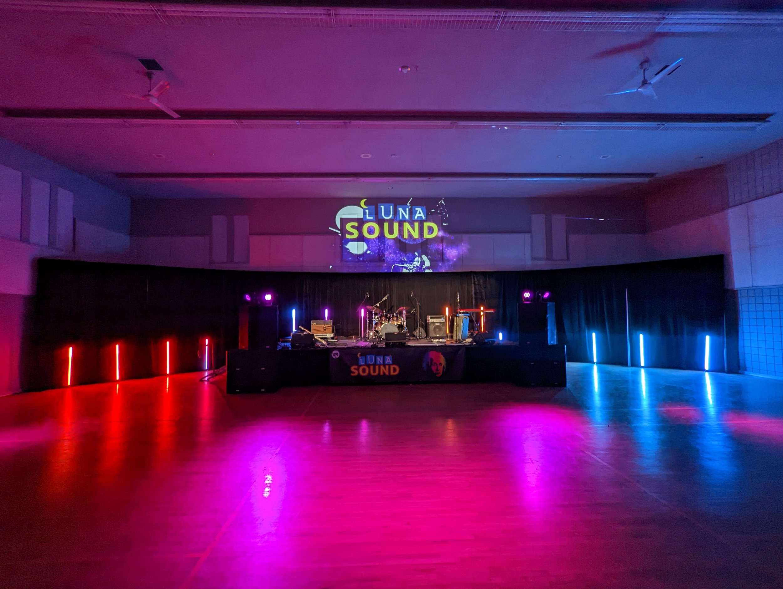 Concert stage setup with colorful lights and 'Luna Sound' projected on the wall.