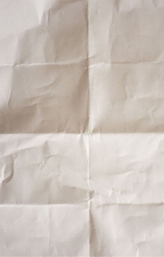 A crumpled sheet of beige and white paper.