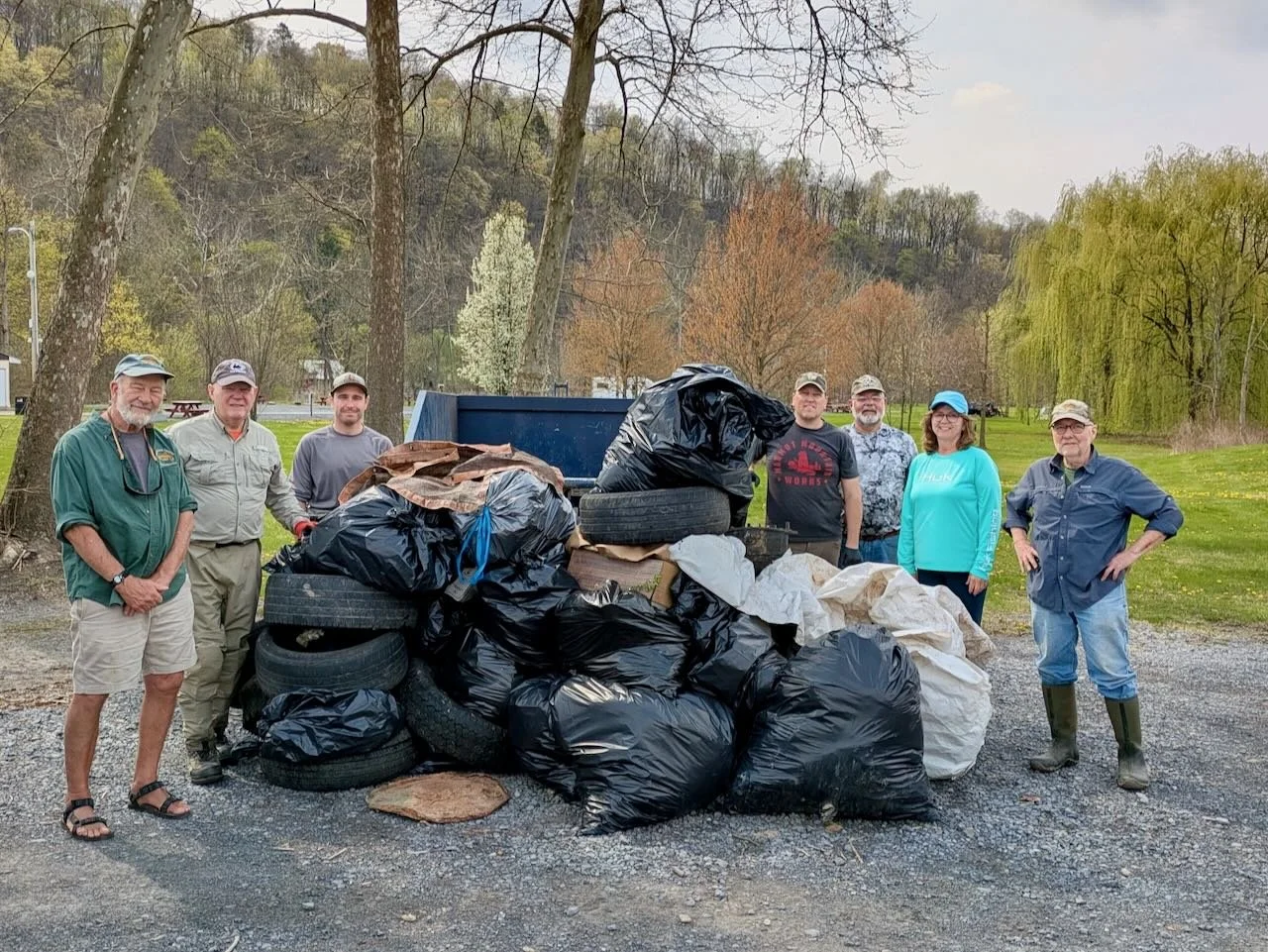 Members of the Penns Creek Chapter of Trout Unlimited standing in front of trash collected during the Chapter's Annual Stream Cleanup