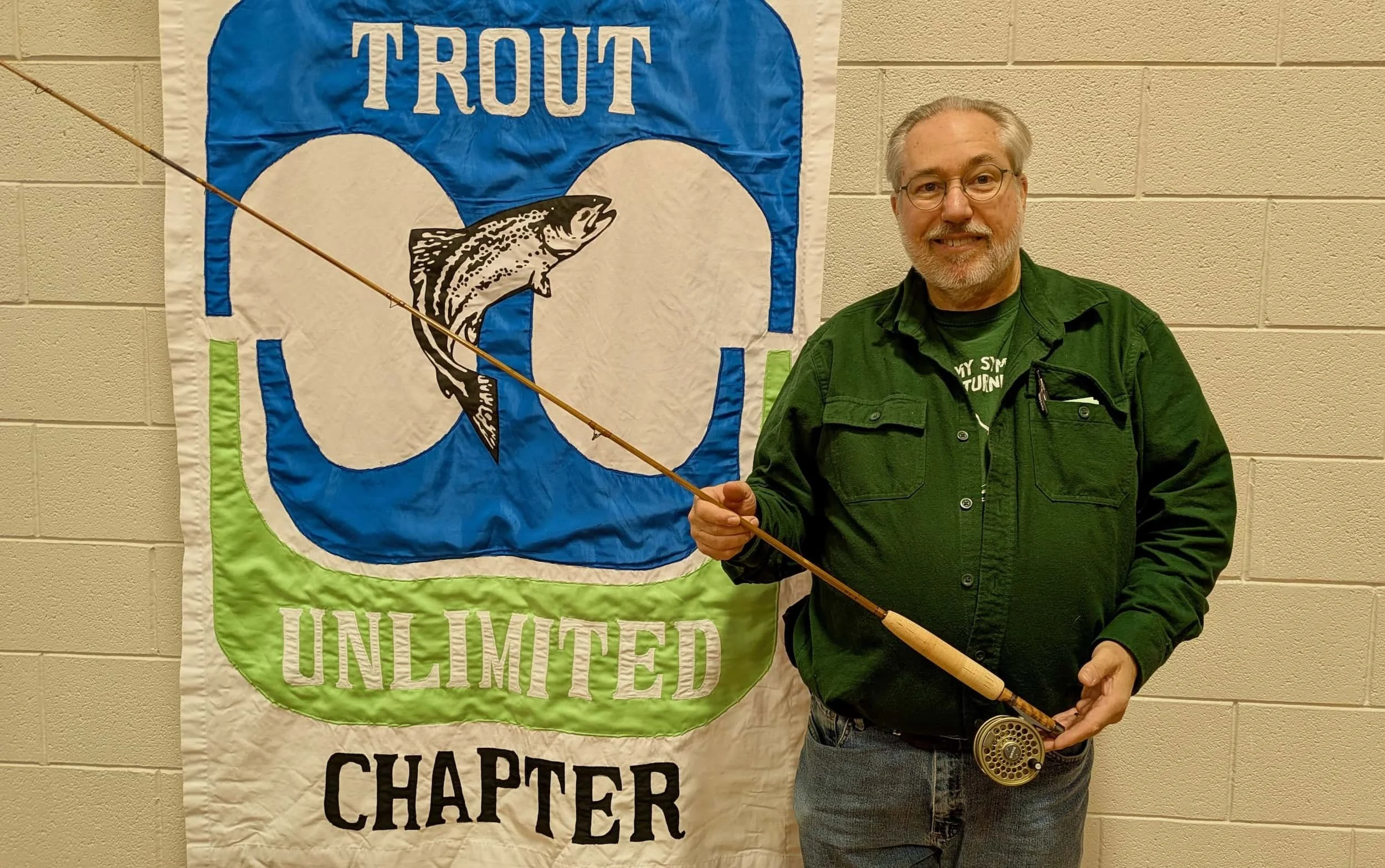 Bob Cross holding one of his handcrafted bamboo fly rod which was raffled off at the banquet
