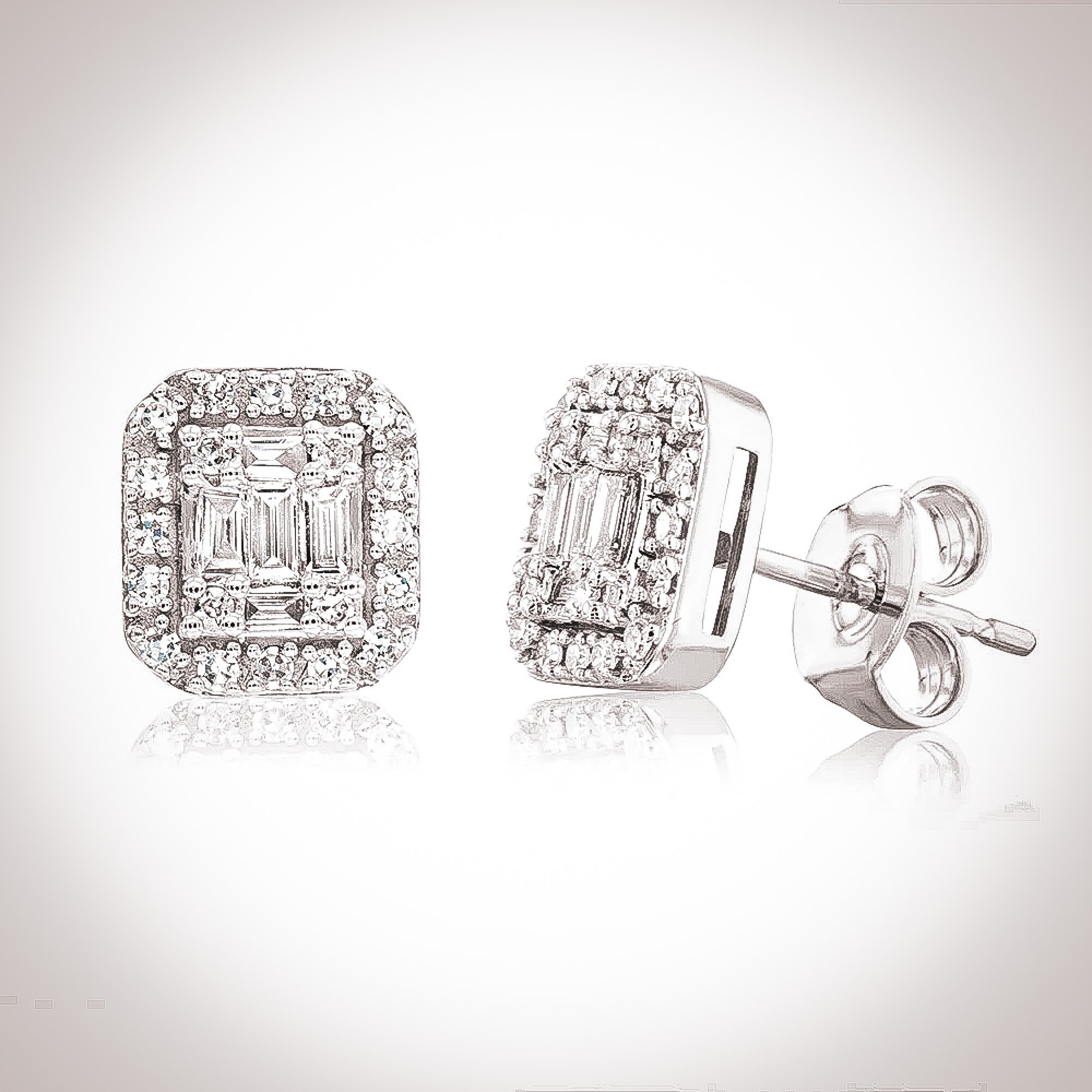Crafted in 18 karat solid white gold, the Fia earrings are elegant and tasteful. Featuring a 0.3ct. (4.5mm x 3mm) emerald cut white moissanite stone framed by moissanite stones per earring.