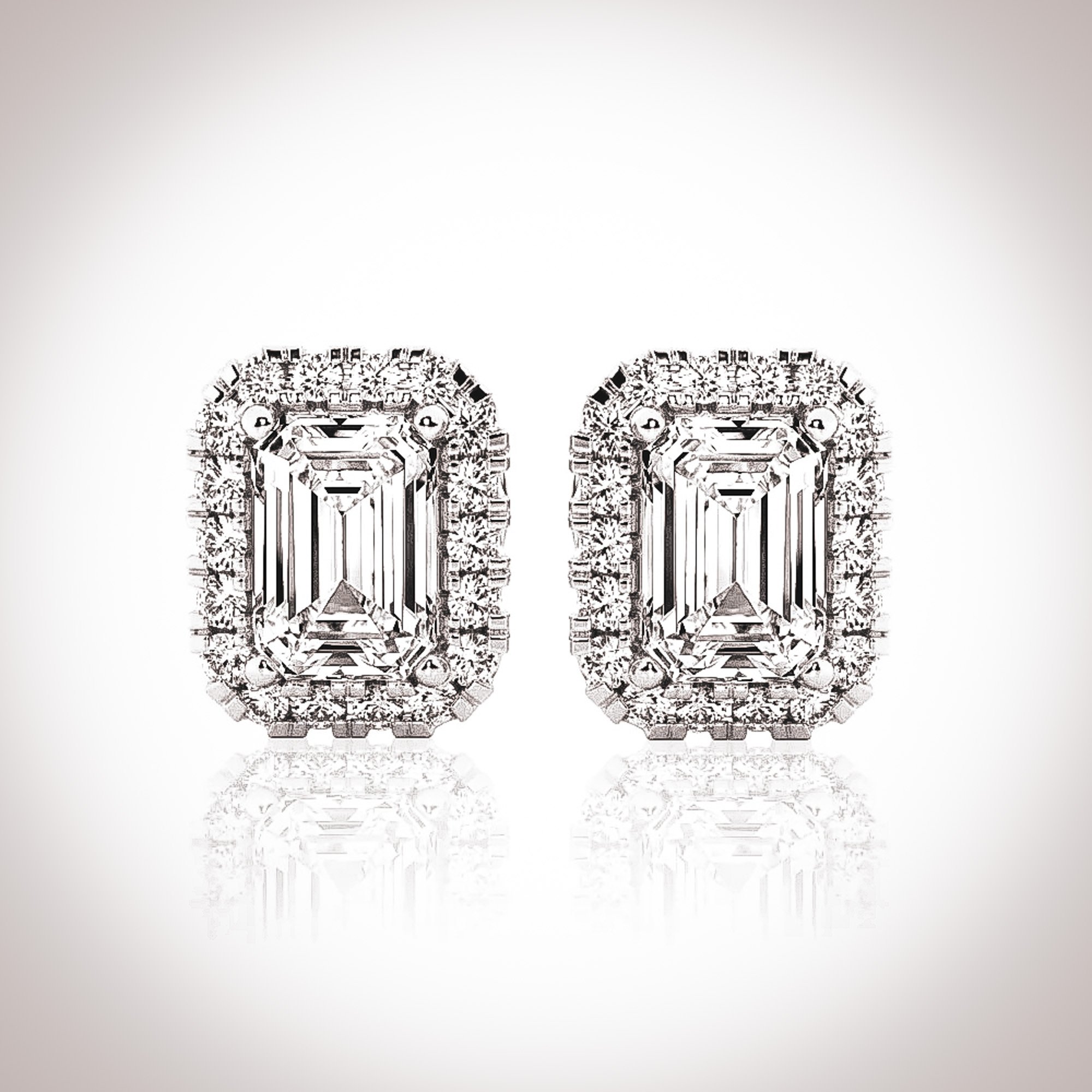 Crafted in 18 karat solid white gold, the Fia earrings are elegant and tasteful. Featuring a 0.3ct. (4.5mm x 3mm) emerald cut white moissanite stone framed by moissanite stones per earring.