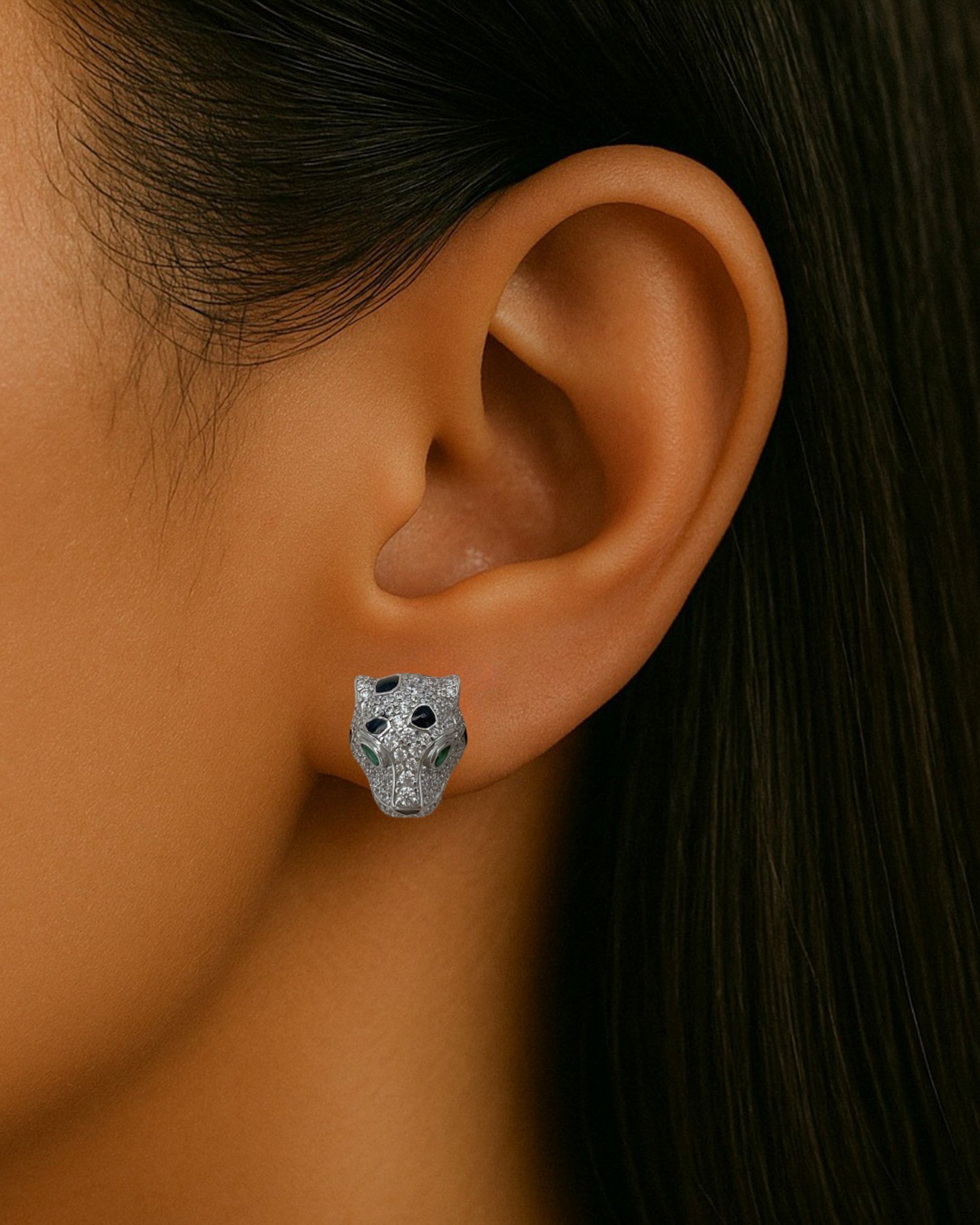 The panther-inspired design is striking and opulent. The face of the panther is adorned by sparkling black and white moissanite stones with green moissanite eyes, 18k solid gold