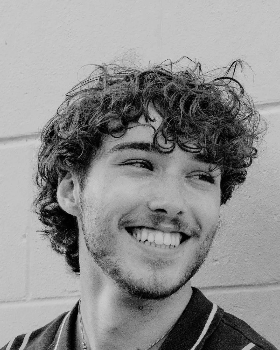 Male smiling after secondary male rhinoplasty surgery to address a deviated septum