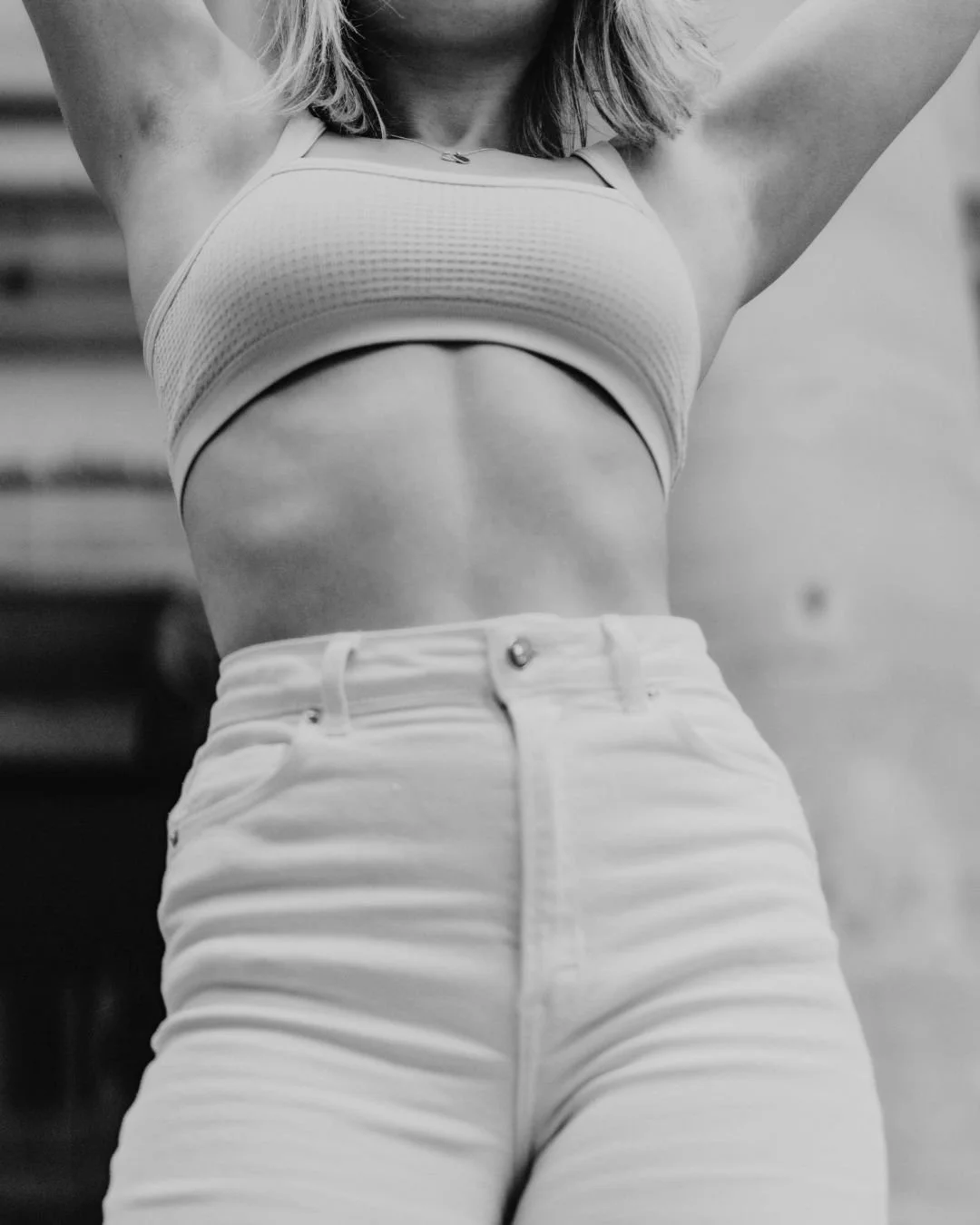 Woman standing with arms above her head and with a natural breast augmentation with a fat transfer​