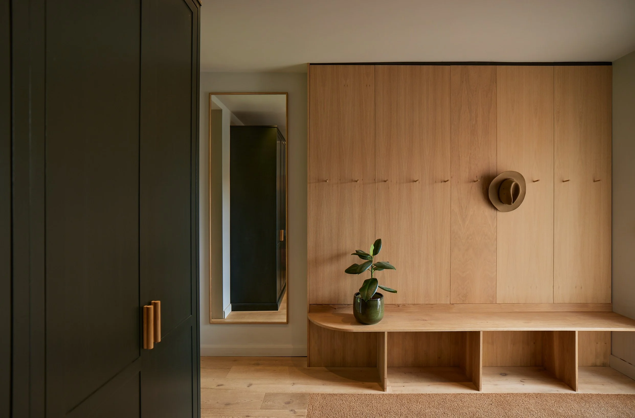 Bespoke oak bootroom with integrated seating and concealed storage at Wynstay House in Nottinghamshire by Boyes Design
