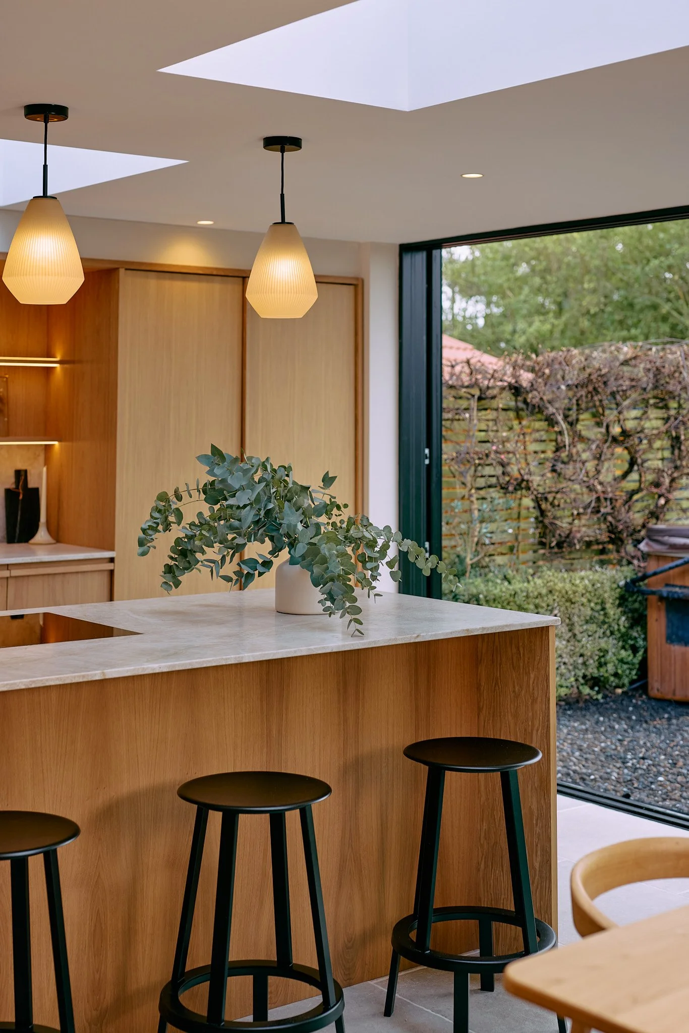 Bespoke oak kitchen island with stone worktop and seating