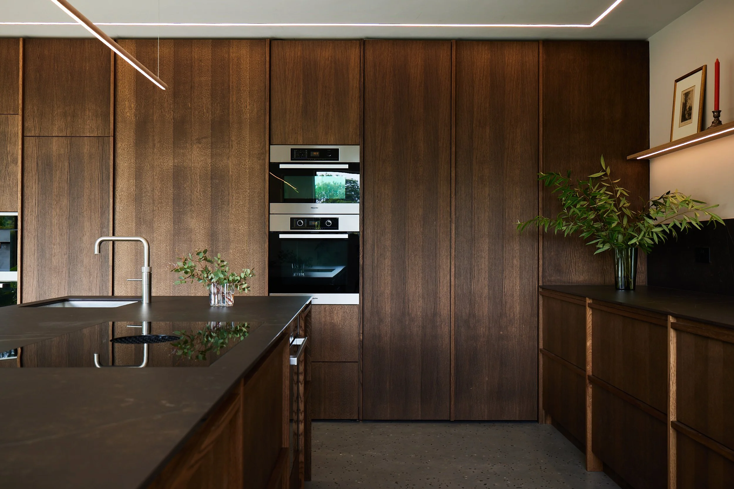 Contemporary bespoke kitchen with natural oak cabinetry and integrated storage at Wynstay House in Nottinghamshire by Boyes Design