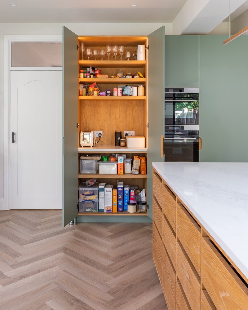 Integrated kitchen storage and hidden cabinetry within a Scandi-style kitchen by Boyes Design.