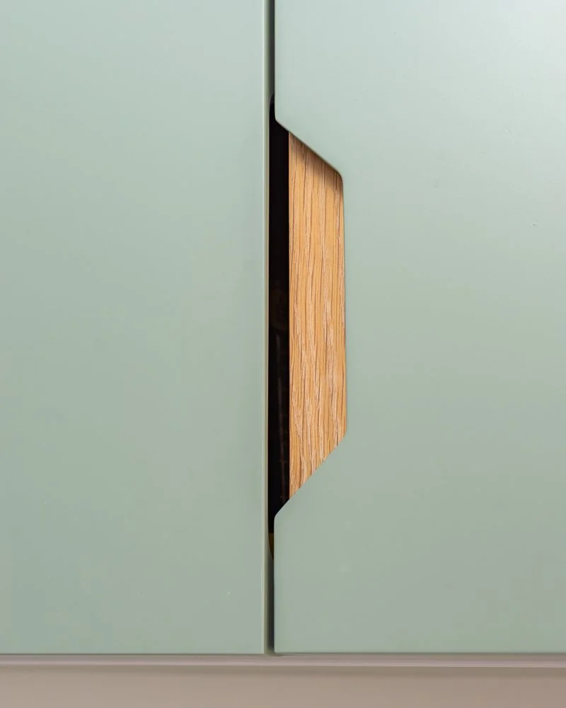 Recessed oak handle detail within painted kitchen cabinetry in West Bridgford interior design project