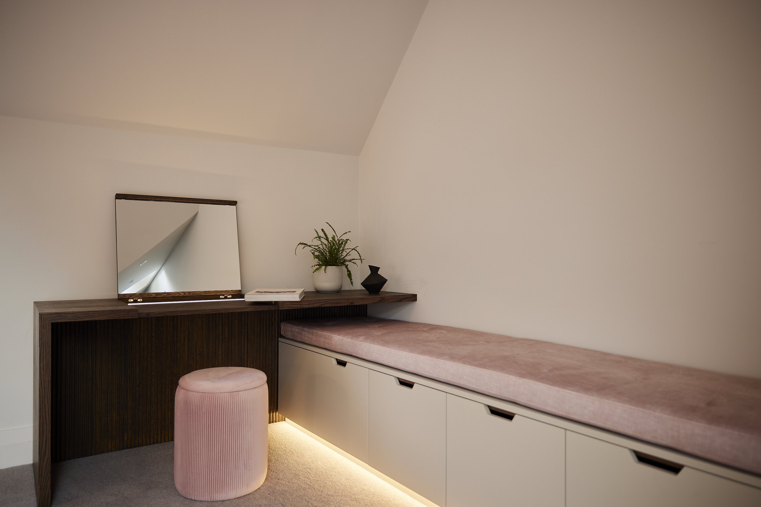 Built-in bedroom bench seating and dressing table designed for a sloped ceiling space