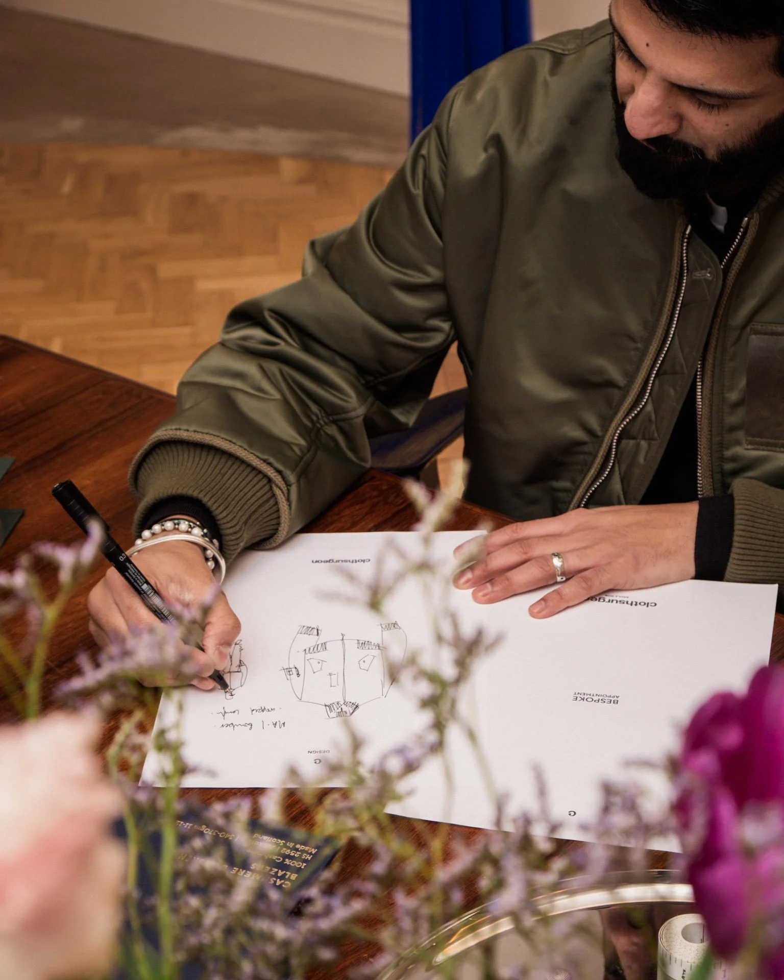 Rav Matharu, founder and creative director of Clothsurgeon, sketching designs at the brand's showroom on Savile Row, London.