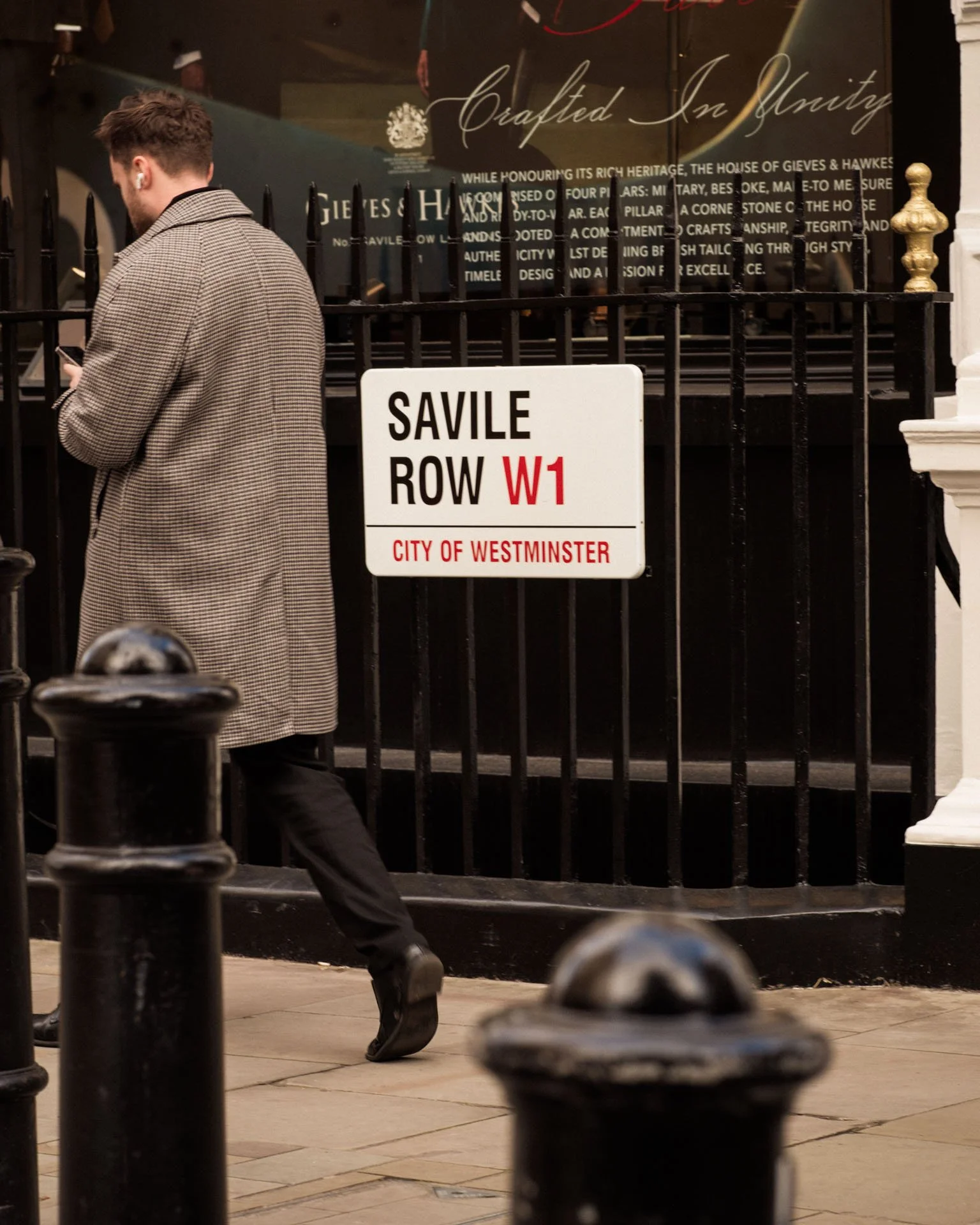 A man walks past a street sign in Savile Row, London.
