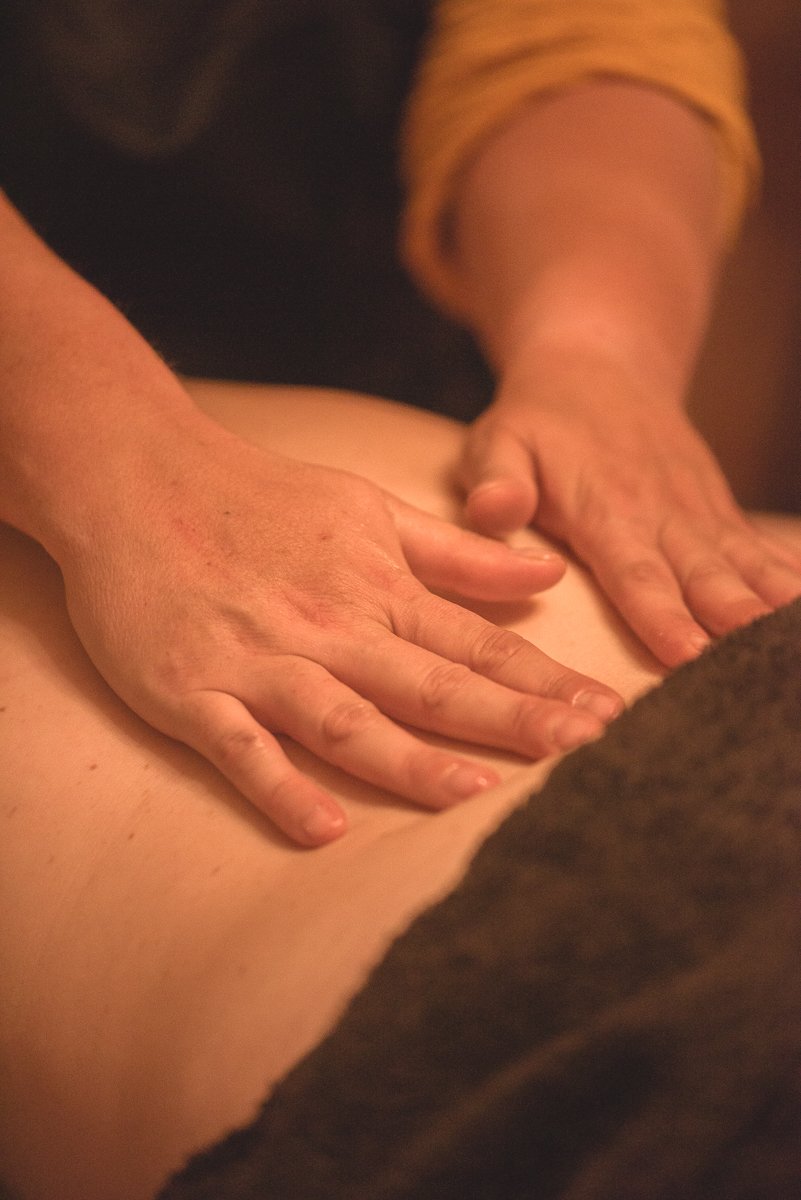 Une personne recevant un massage du dos dans un environnement de détente.