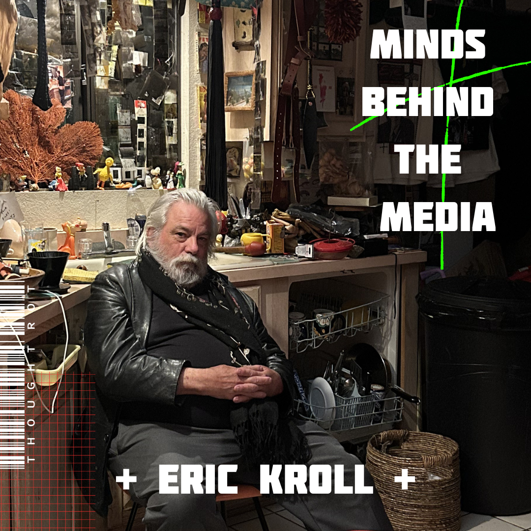 A man with a white beard and gray hair sitting on a chair in a cluttered room, surrounded by various objects and decorations, with the text 'Minds Behind The Media' and '+ Eric Kroll +' overlaid.