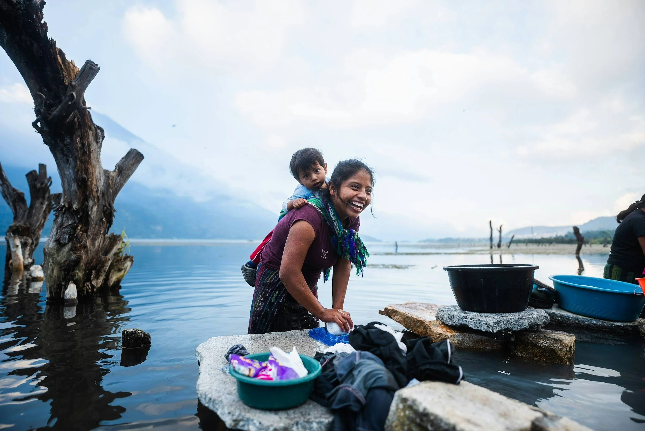 Woman with child on back in tropical setting