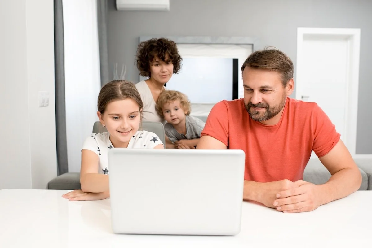 A family looking at a laptop planning for 2026