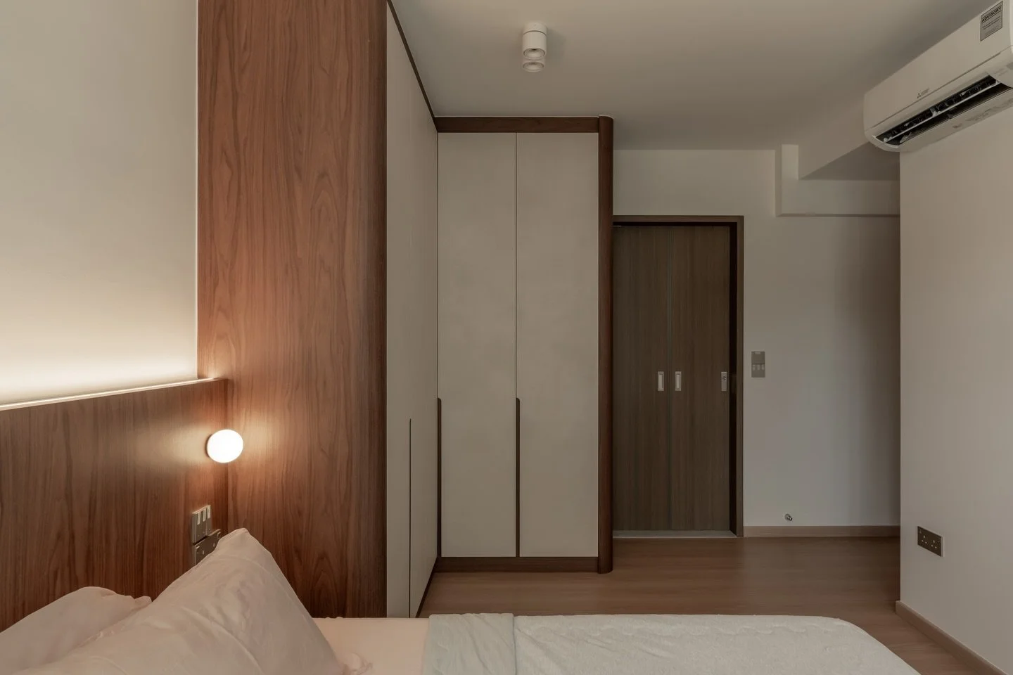Rather than treating storage as a separate element, the wardrobe becomes part of the room&rsquo;s architecture. Rounded corners soften transitions, while repeated tones and finishes create a sense of visual continuity, allowing each component to feel