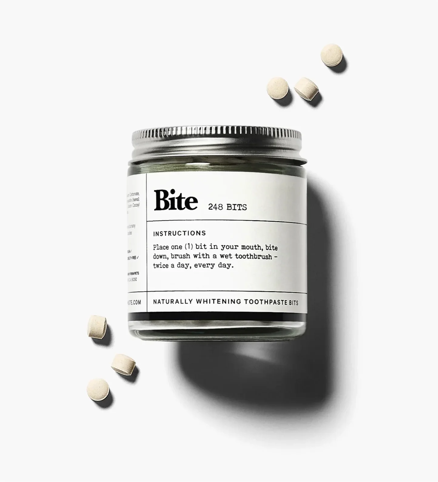 bite toothpaste jar with tooth paste bites scattered around.