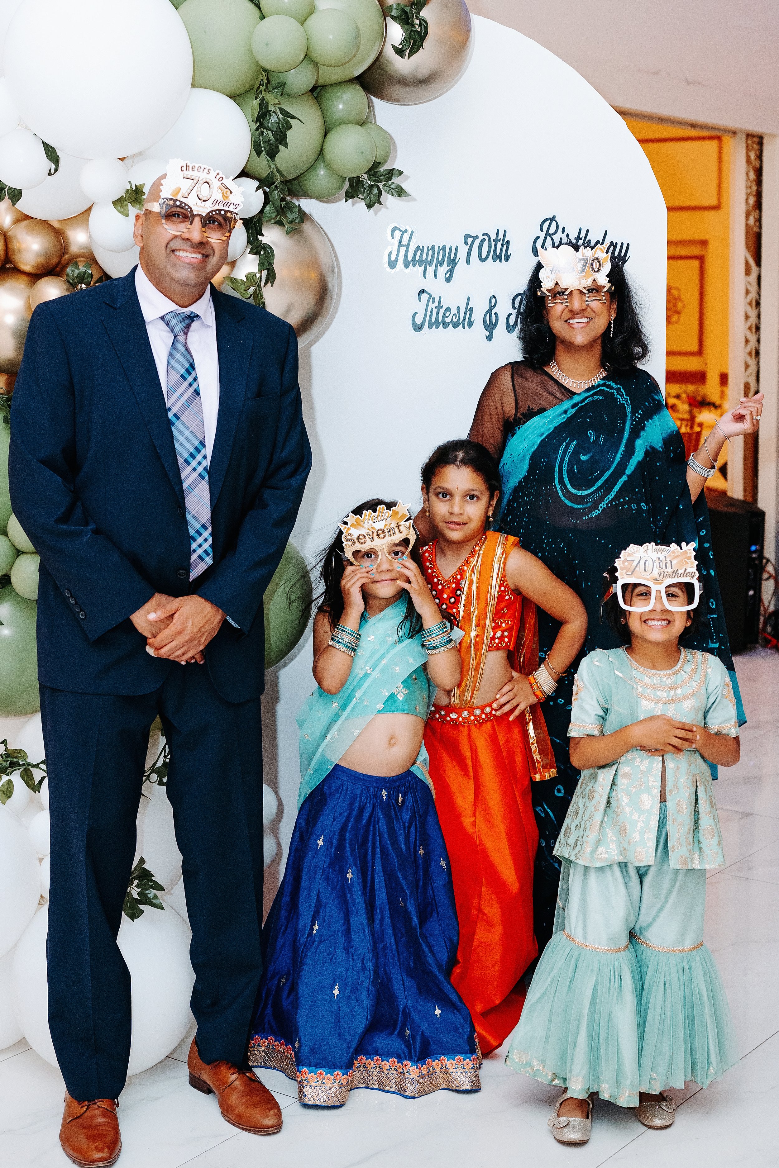 Family celebrating 70th birthday, with balloons and birthday decorations in a festive setting.