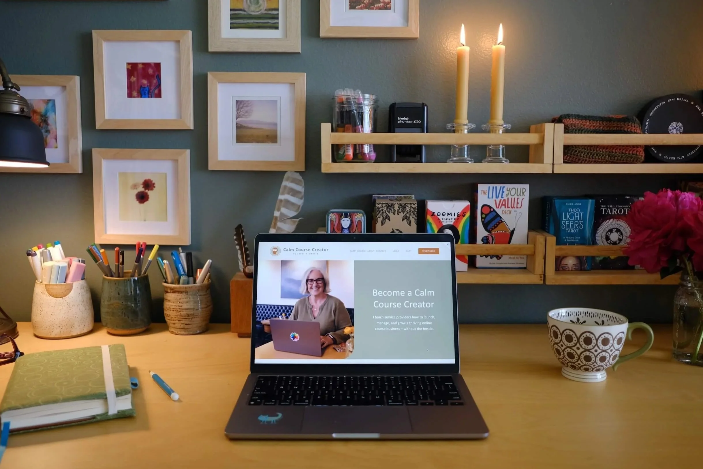 Photo of Kerstin's home office desk with the Eule Planner, a cup of coffee and an open laptop showing the Calm Course Creator sales page.